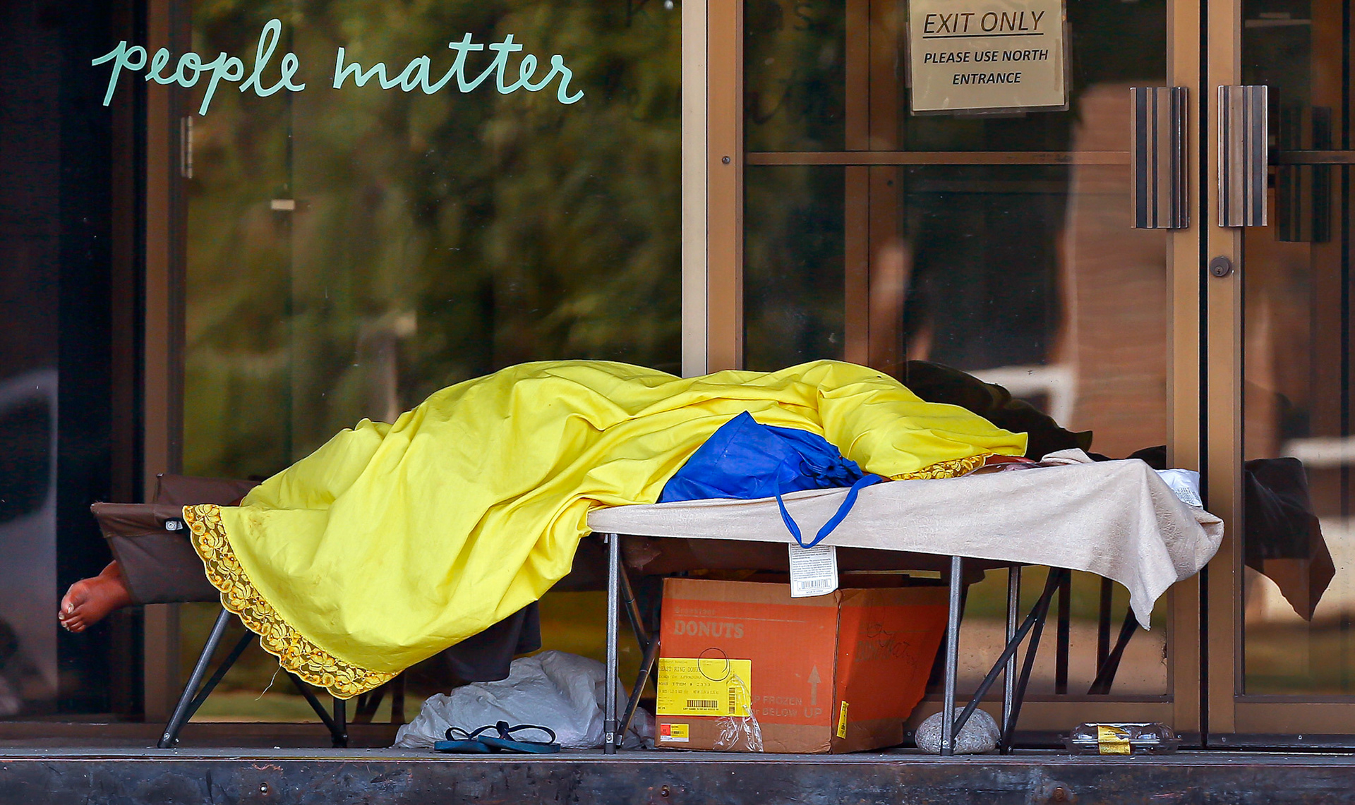 A homeless person sleeps on a cot in the doorway of the KVC Kansas building in downtown Topeka, Kan. The City of Topeka announced Friday it was teaming up with numerous community partners to create Impact Avenues, a program aimed at helping the 750 to 1,000 homeless students in the community, and their families, obtain stable housing. 
