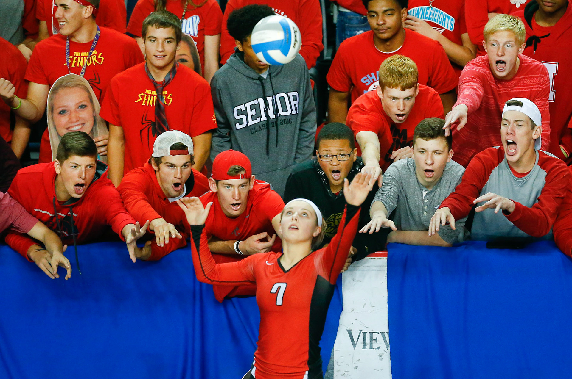The Shawnee Heights student section heckles Lansing's JoLee Ritchhart as she serves the ball during Friday afternoon's 5A state quarterfinals at the Kansas Expocentre.