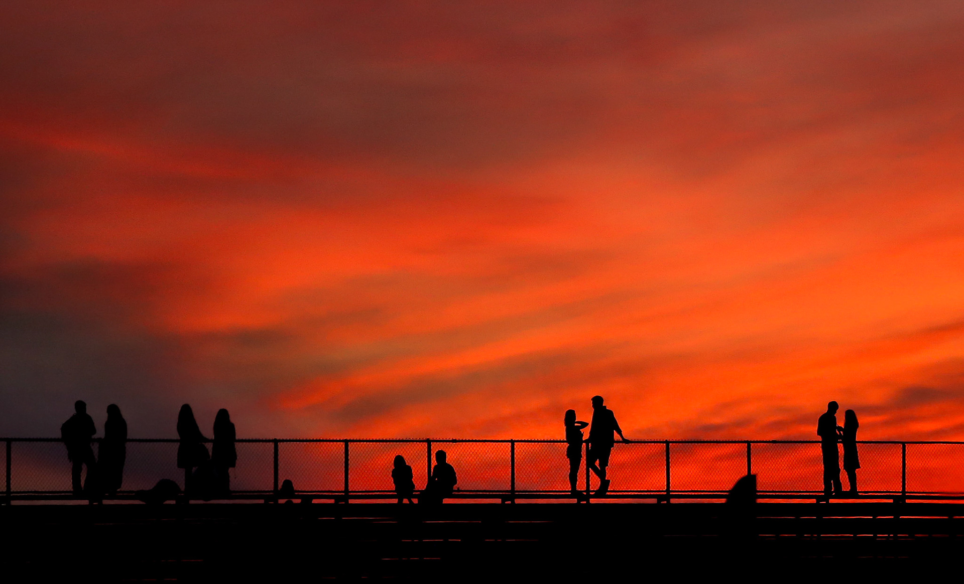 Couples take in the view from the stands at Heartland Park as the sun begins to set during the Lantern Festival on Saturday July 15, 2017. (Chris Neal/The Capital-Journal)
