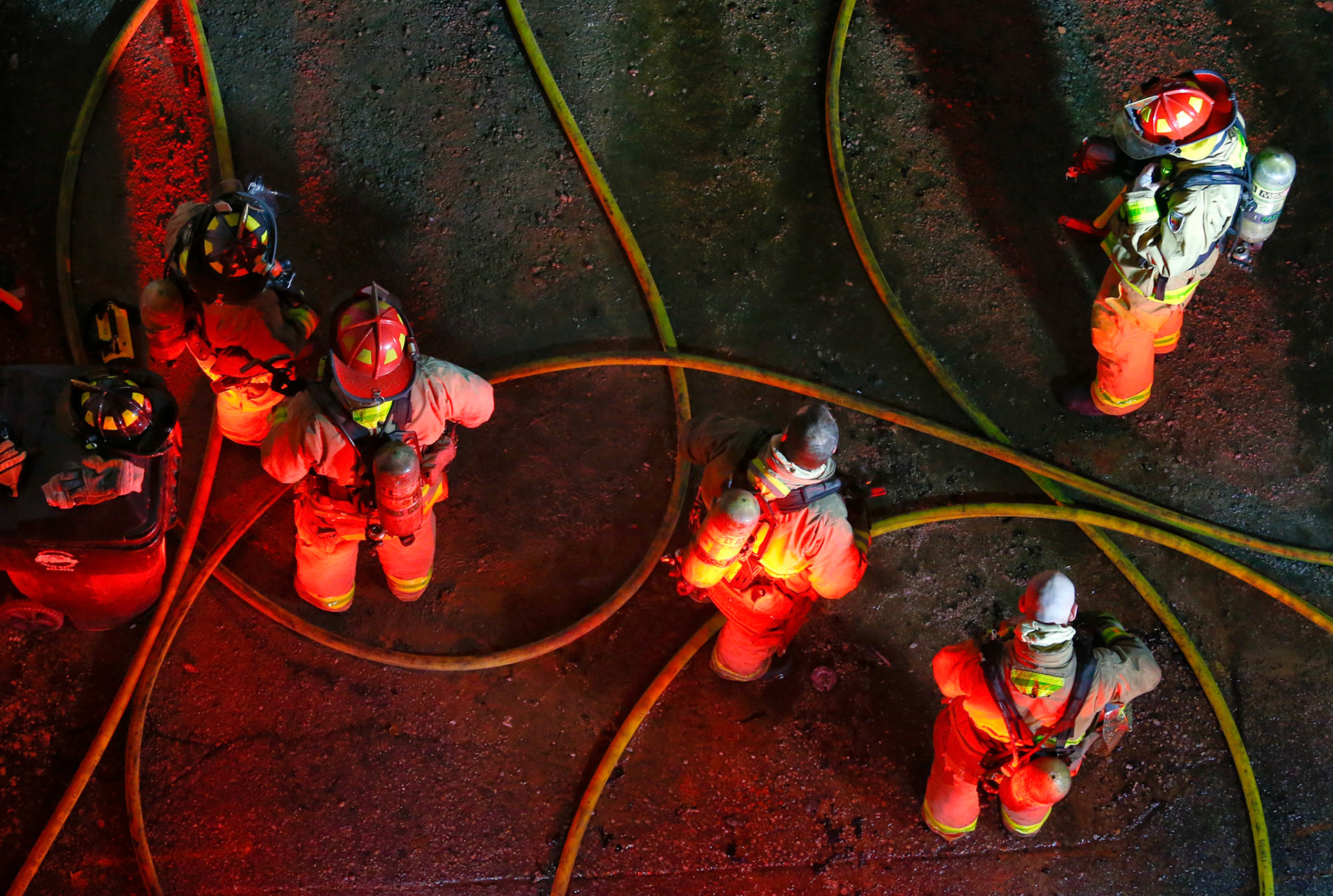 Firefighters wait for their turn to work on putting out a fire on the backside of HHB BBQ in downtown Topeka, Kan., on Friday Jan. 2, 2015, where a fire caused the back half of the building's roof to collapse.