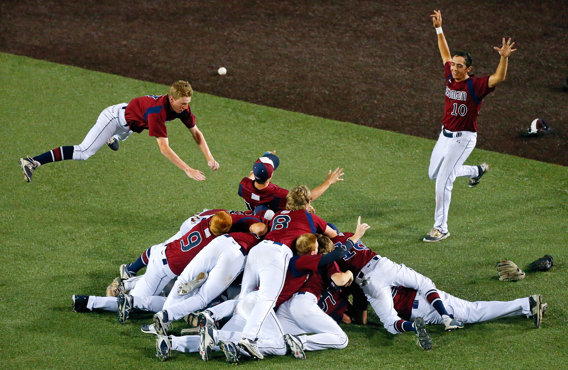 Seaman's Trent Cox, left, and Brock Hillebert, right, run in front the outfield to join in on the dog pile after the Vikings defeated the Bishop Carroll Golden Eagles, 7-2, to win the 5A baseball championship at Eck Stadium in Wichita, Kan.