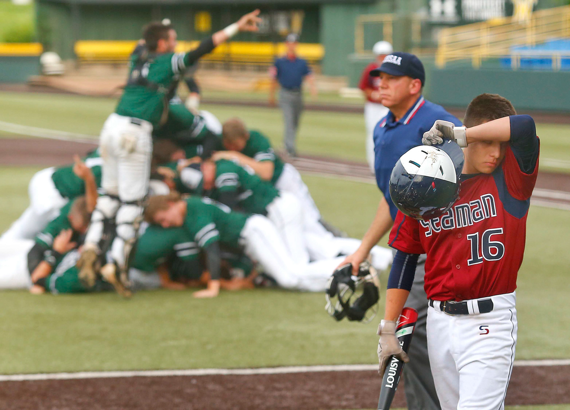 Seaman's David Lucero walks off the field as Blue Valley Southwest celebrates their 2 to 1 victory over the Vikings in the 5A Baseball Championship at Eck Stadium in Wichita, Kan.