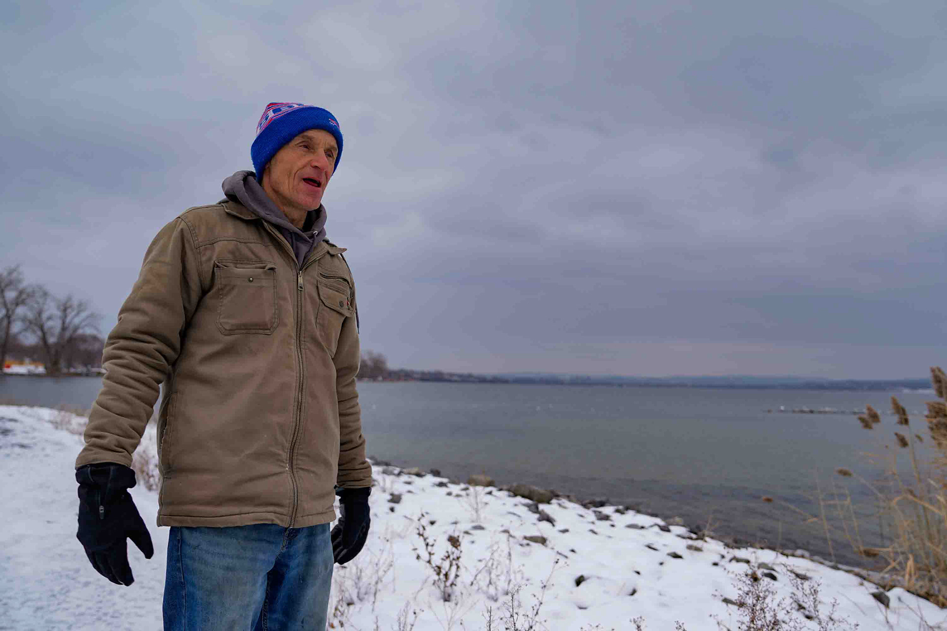Local Liverpool resident Tim reflects on his decision to move from Cortland to Liverpool by Onondaga Lake on Sunday, December 7. Tim grew up in Cortland and remembers the lake from his childhood. "People used to get sick even walking by the lake," Tim said. "But even as kids we would come down to the lake with bows and arrows and shoot the carp sitting in the algae along the shore."  Tim states that he believes the lake is the cleanest it has been in 125 years, and even as he has grown more conservative in his older  age, the importance of protecting the lakes ecology has never been more important to him.