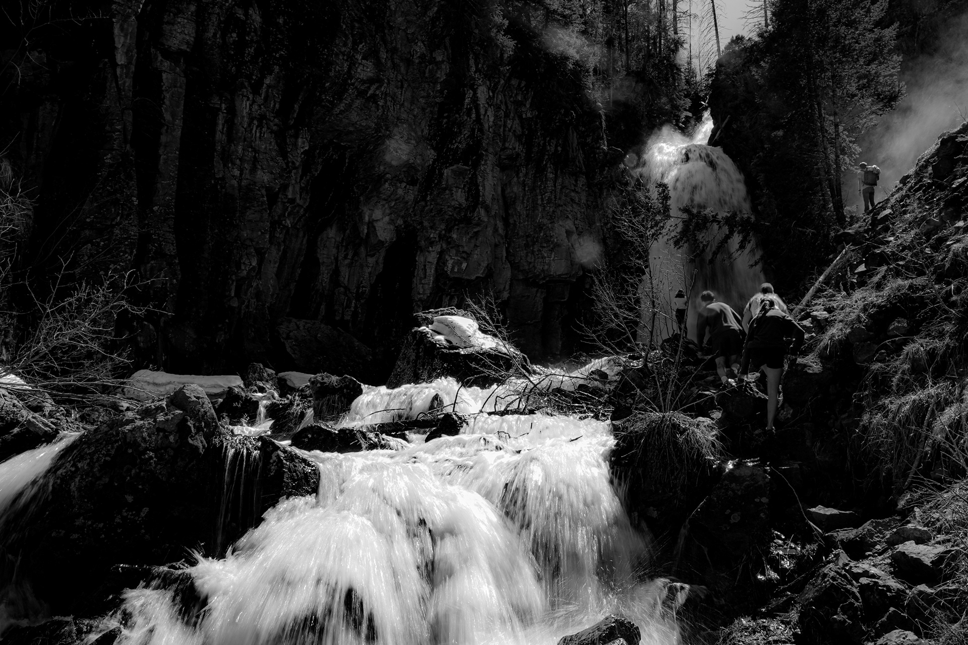 Staff members hike to the local waterfall to check snowmelt and water levels before guests arrive at the beginning of the season.