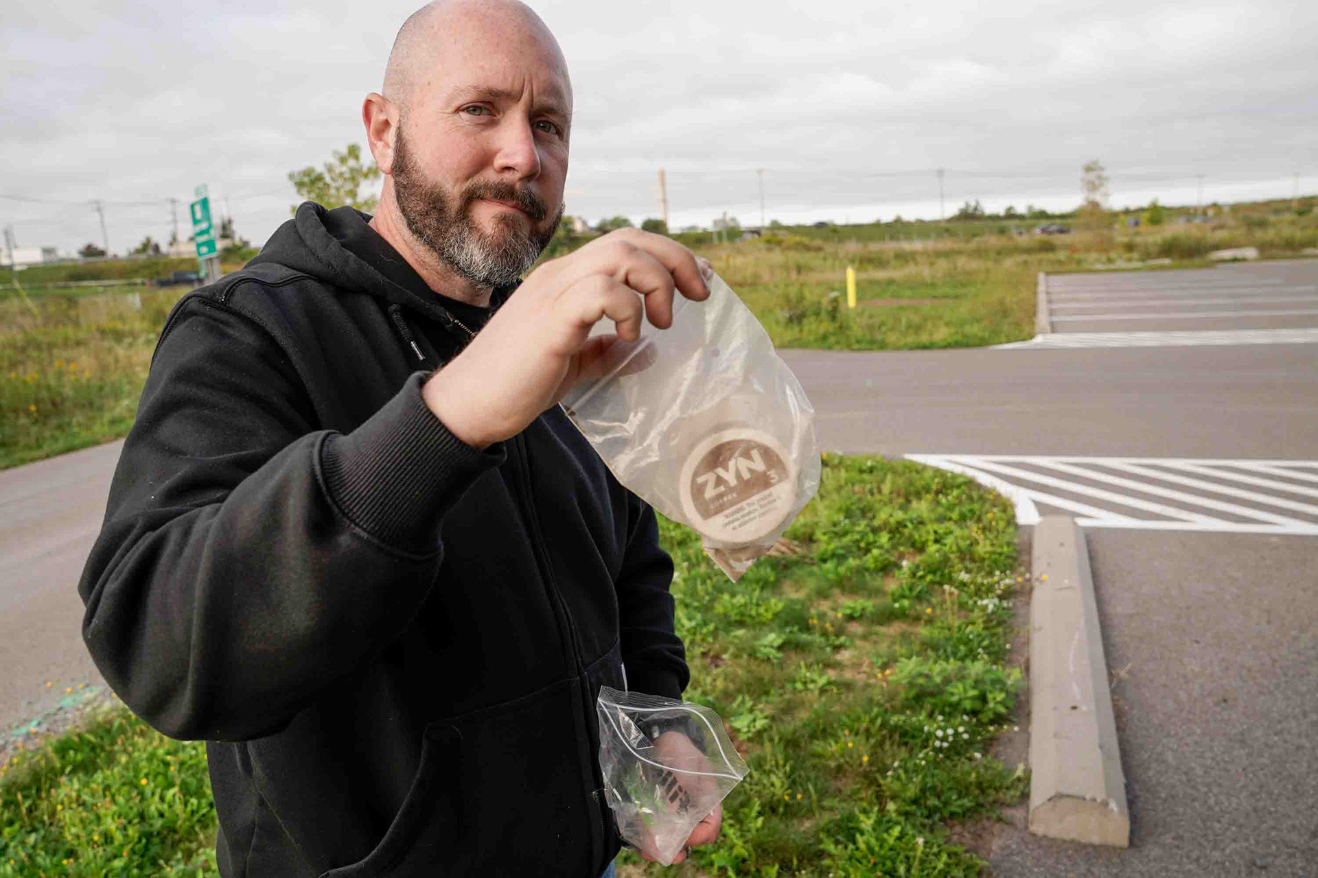 Dave Smith holds up Zyn can on Friday, October 3 next to Onondaga Lake which contains a soil sample he collected from under an area where runoff was still seeping into the lake. Smith says he is waiting to test it until he can find a place he trusts will do the right things with the sample.