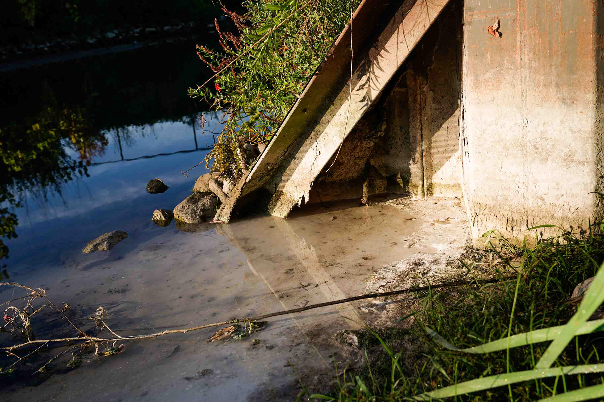 A white substance leaks from underneath a retaining wall across from Highway 690 on the south side of Onondaga Lake on Wednesday, September 30. Retention walls were the solution to run off on the majority of the south side of the lake, and many of them have weakened and fallen into disrepair since being installed in 2006.