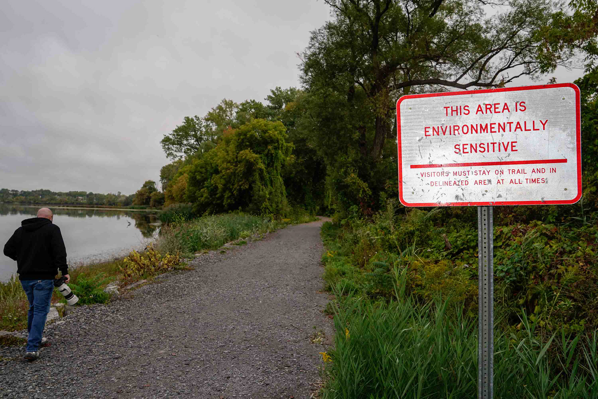 Dave Smith walks along the Murphy's Island coast of Onondaga Lake on Friday, October 3. While both wildlife and community have come back to the lake, the reminders of the lake's past, and present, linger. To Smith and other community members like him, the lack of ability to purge the surrounding area of chemical pollutants is a majorly overlooked concern.