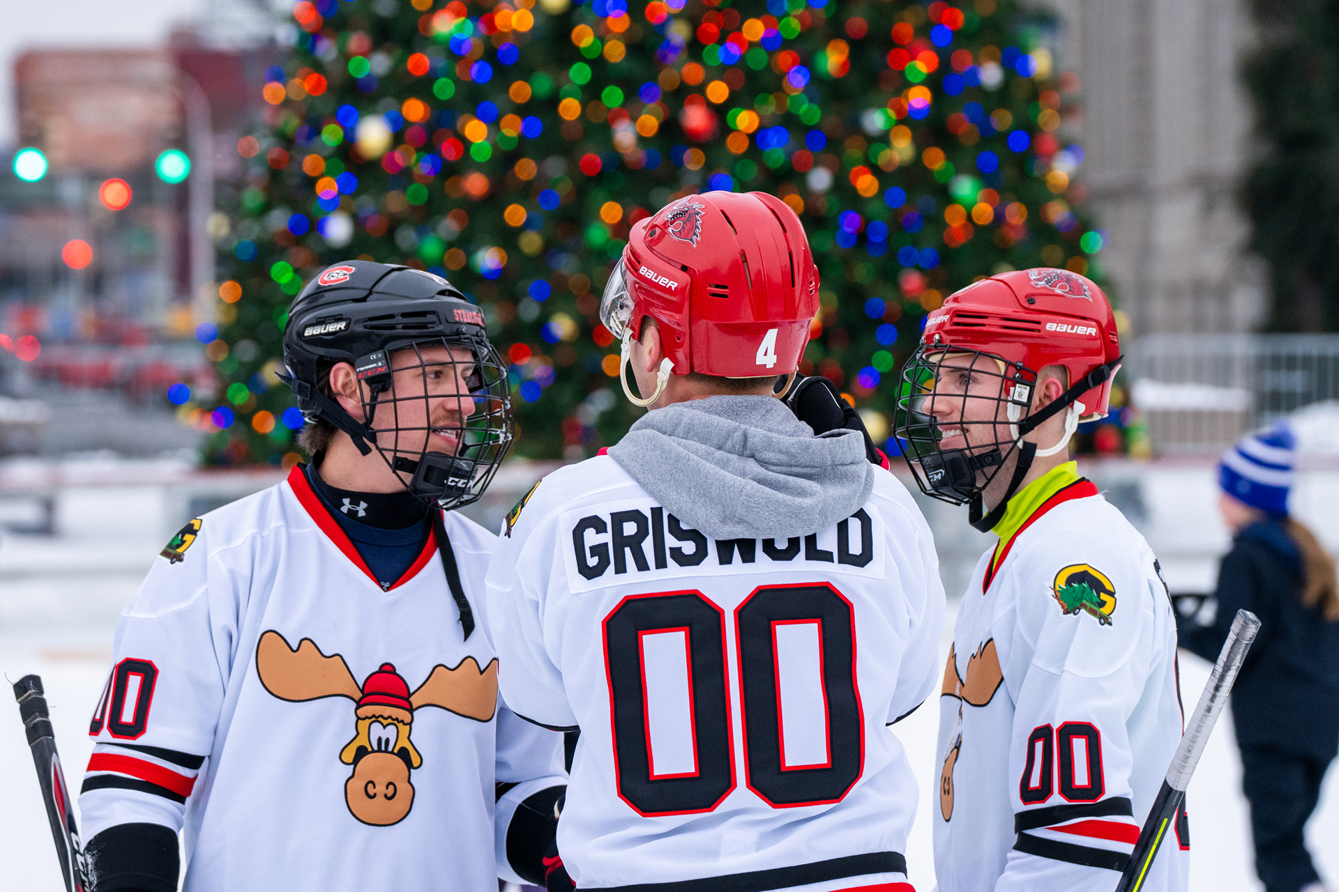 Players from the Griswold team game plan on the ice during the Syracuse Pond Hockey Classic.