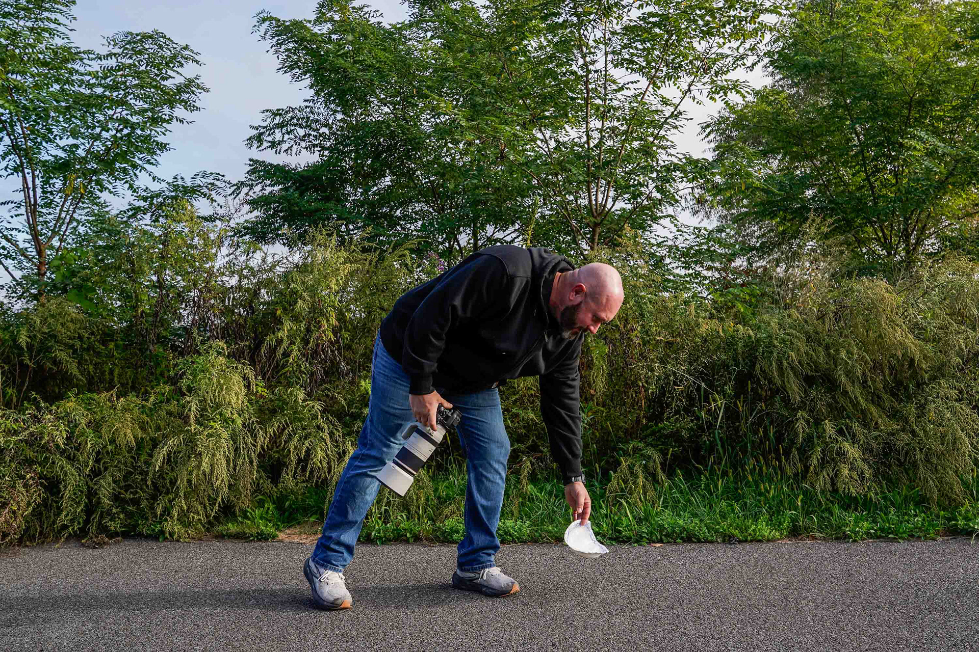 Dave Smith reaches down to pick up trash along the Onondaga Lake Trail on Friday, October 3. The Liverpool local walks the trail every other day at sunset, looking for wildlife and cleaning up what he can on his way. Smith began walking along the waters 2 years ago, and has spent his early mornings in this way since then.