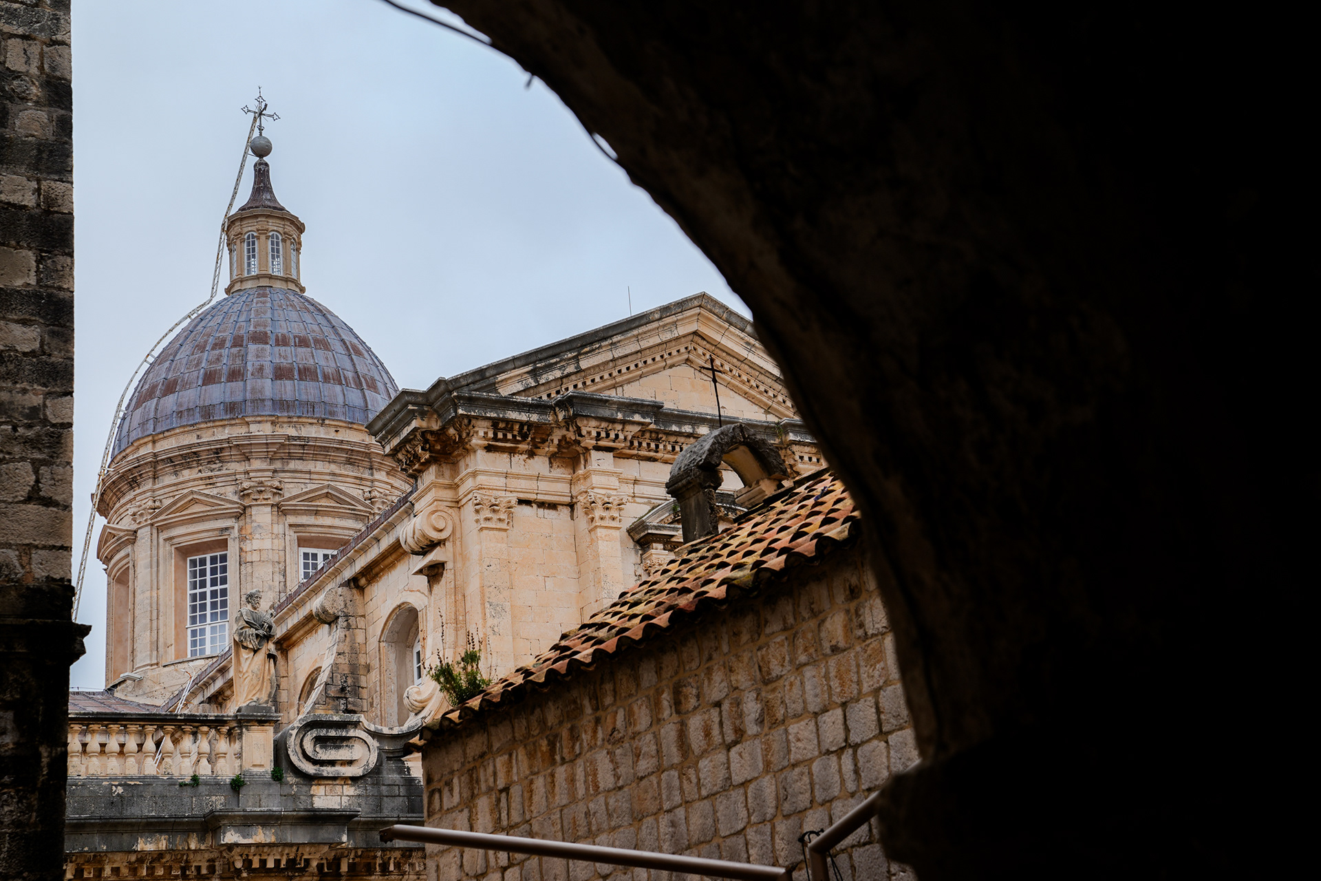 Construction scaffolding surrounds Dubrovnik’s Assumption Cathedral, where bomb damage and residue from the war still lingers—a reminder that tourism thrives alongside ongoing restoration.
