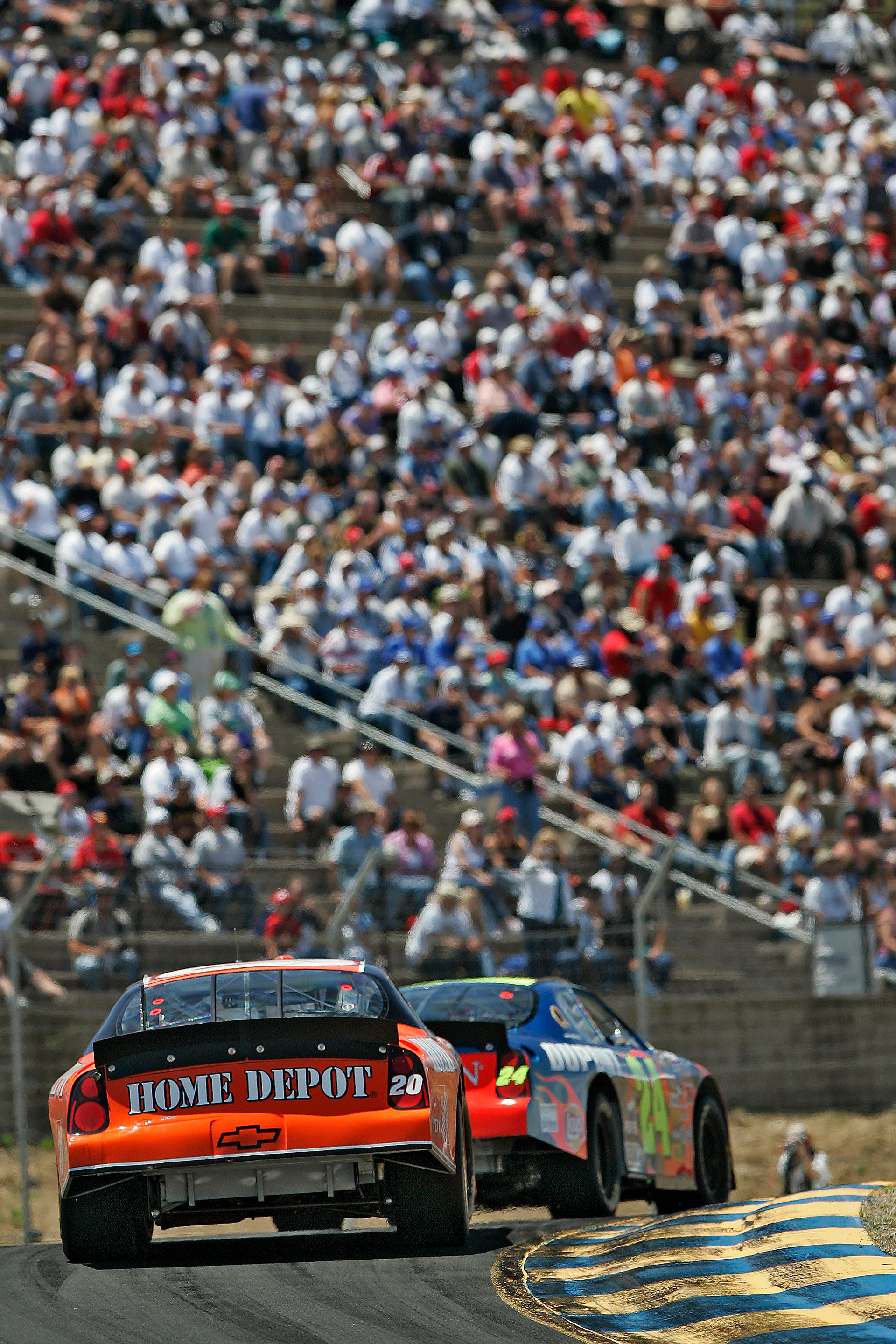Jeff Gordon leads Tony Stewart past the packed spectator terraces in Turn 2 at Sonoma.  ©  IAN DONALD