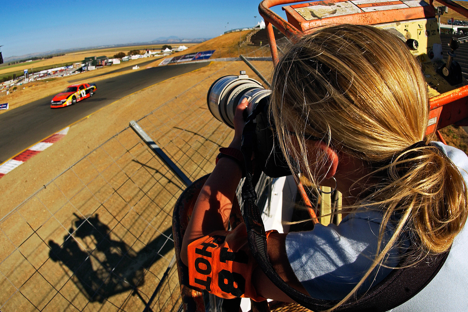 Above the safety fence in the bucket lift - looking for the "Air Shot" in Turn 3 at Sears.  ©  IAN DONALD