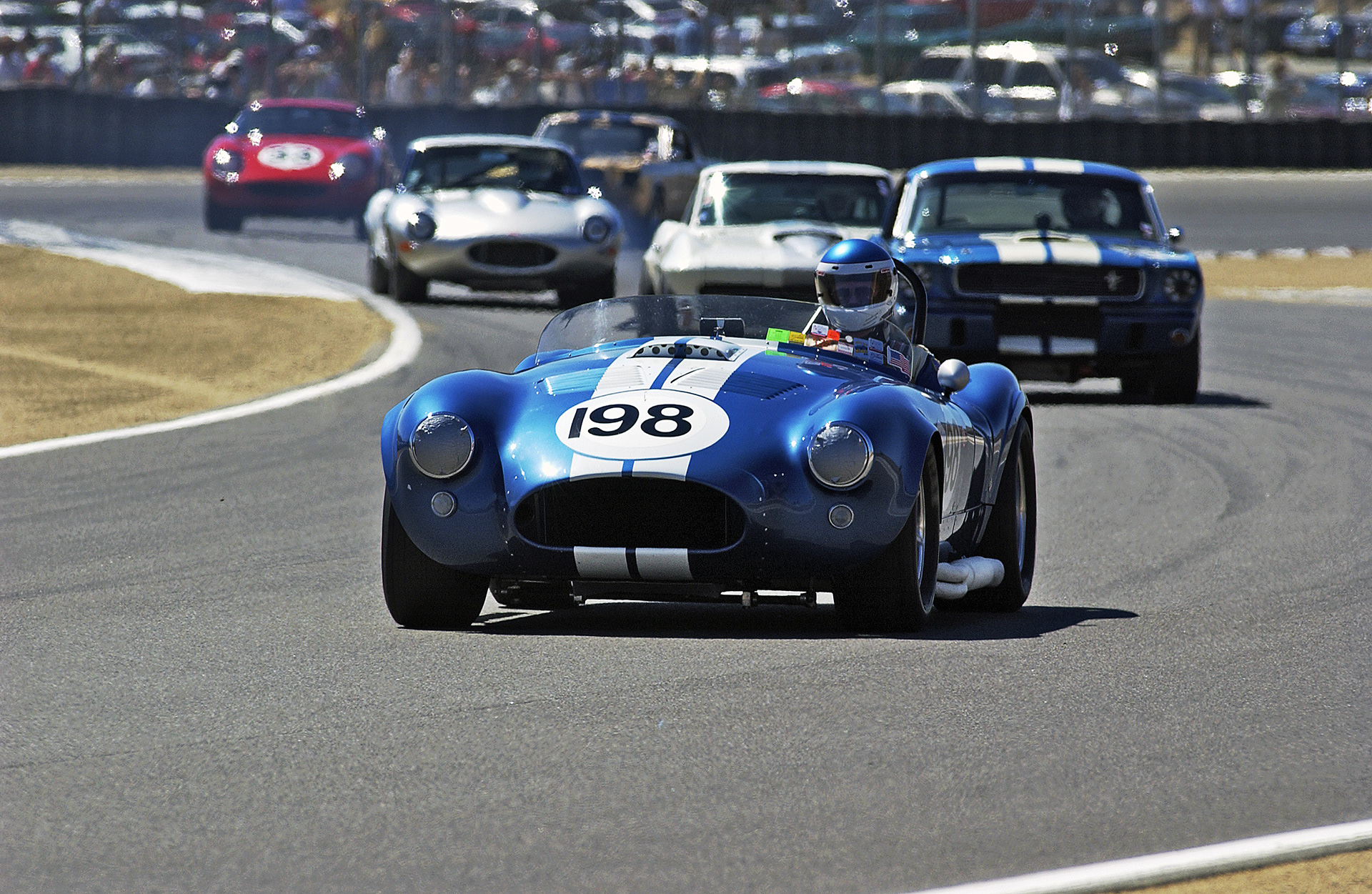 Shelby Cobra leads a Mustang, Corvette, E-Type and a Ferrari at Monterey.  ©IAN DONALD