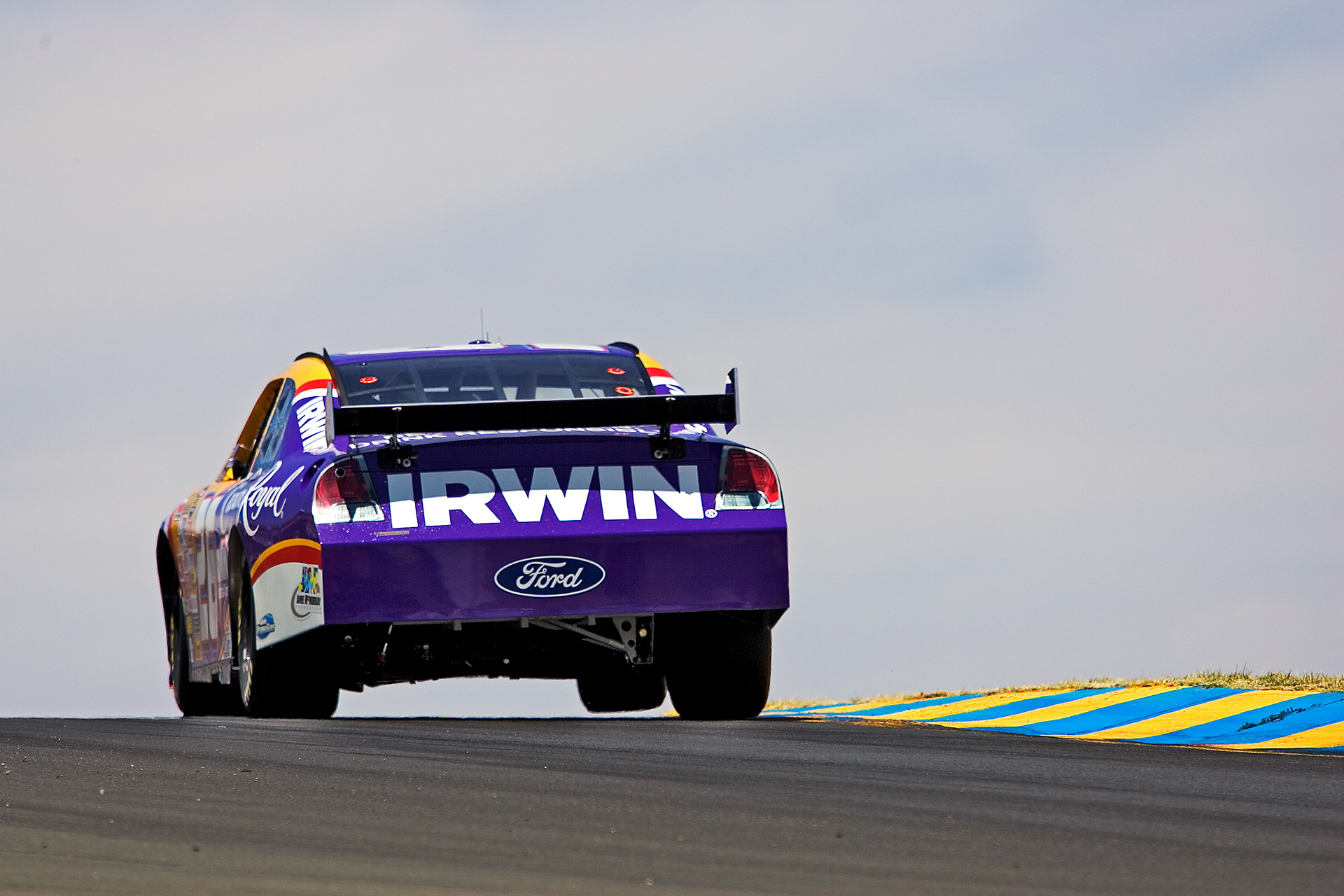 Jamie McMurray's #26 Crown Royal Ford Fusion lifts a wheel in Turn 3B at Sonoma. ©  IAN DONALD