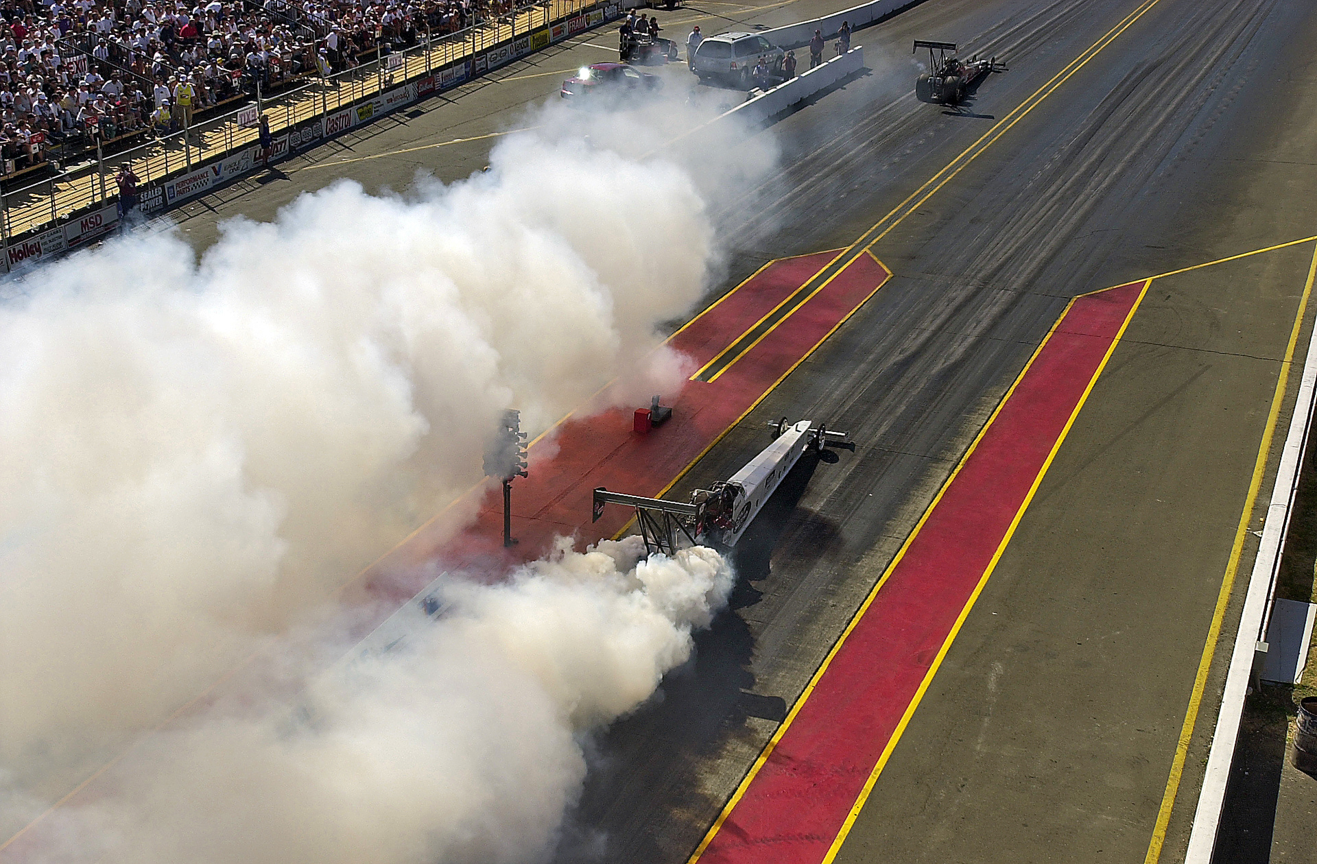 Double Top Fuel car burnout shot from the roof of the NHRA Tower. Up there, the stench of Nitro and the flying chunks of debris and unburnt fuel being sent skywards could get your attention - fast...  © IAN DONALD