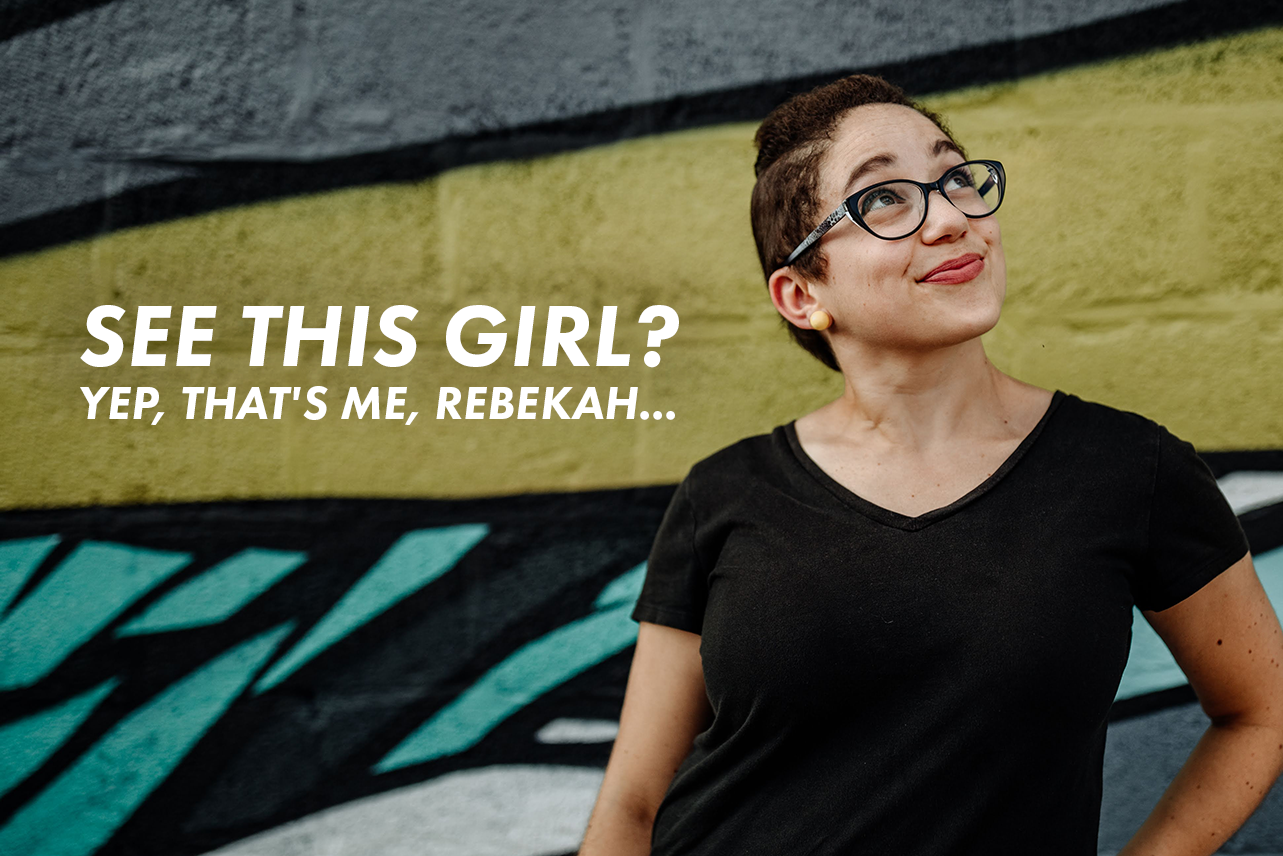 Becky, a bi-racial young woman with pixie-cut hair and black shirt, is seen looking towards the sky while smiling in front of a graphic-style mural. Written on the image, "See this girl? Yep, that's me, Rebekah...".