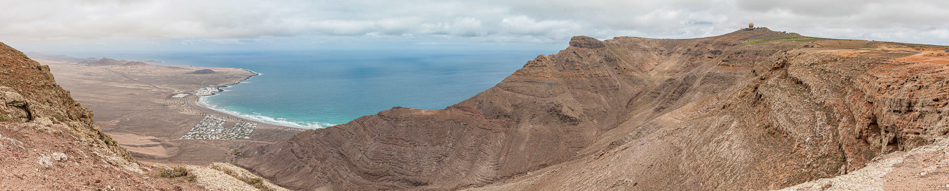 Blick von der Ermita de las Nieves, an der Küste Caleta de Famara, rechts Militärstation auf dem Peñas del Chache