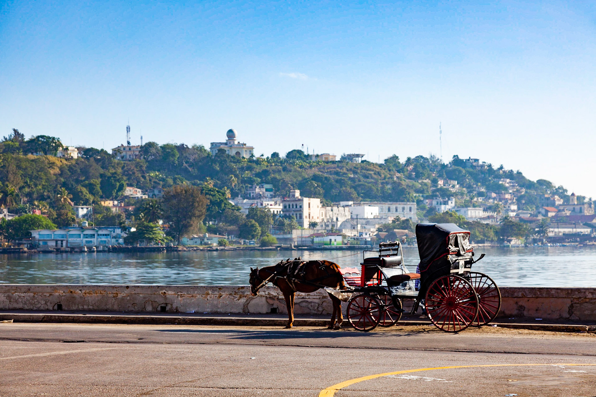 Havana lies on the northern coast of Cuba, south of the Florida Keys, where the Gulf of Mexico joins the Atlantic Ocean. The city extends mostly westward and southward from the bay, which is entered through a narrow inlet and which divides into three main harbours: Marimelena, Guanabacoa, and Atarés. The sluggish Almendares River traverses the city from south to north, entering the Straits of Florida a few miles west of the bay.  The city has long been a popular attraction for tourists. Between 1915 and 1930, Havana hosted more tourists than any other location in the Caribbean. The influx was due in large part to Cuba's proximity to the United States, where restrictive prohibition on alcohol and other pastimes stood in stark contrast to the island's traditionally relaxed attitude to leisure pursuits.