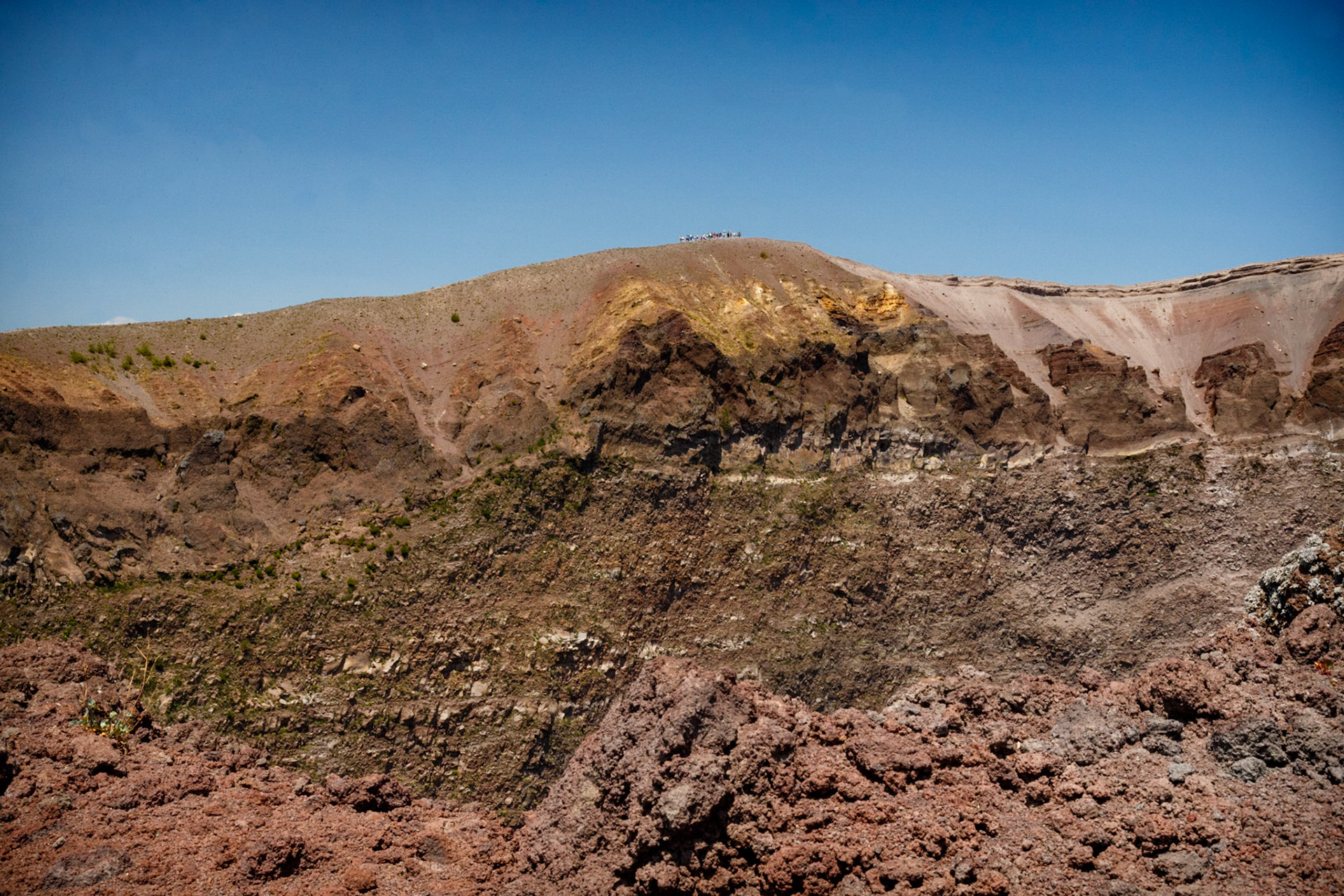 The still smoking crater of Vesuvius.  The huge size of the volcano can be estimated by looking at the group of people on the edge of the crater at the far side.