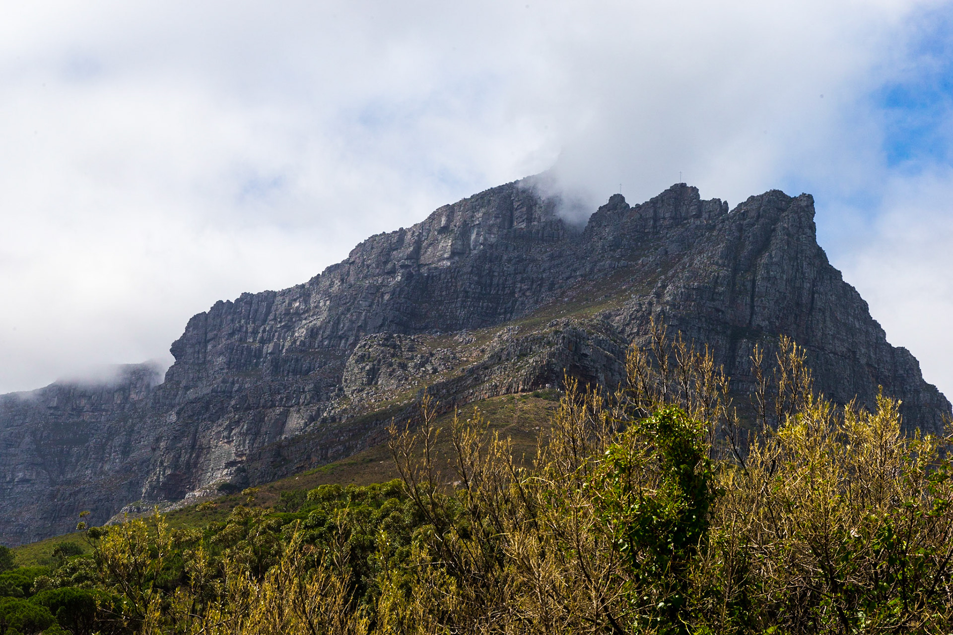 Table Mountain (Khoikhoi: Hoerikwaggo, Afrikaans: Tafelberg) is a flat-topped mountain forming a prominent landmark overlooking the city of Cape Town in South Africa, and is featured in the Flag of Cape Town and other local government insignia.[2] It is a significant tourist attraction, with many visitors using the cableway or hiking to the top. The mountain forms part of the Table Mountain National Park.