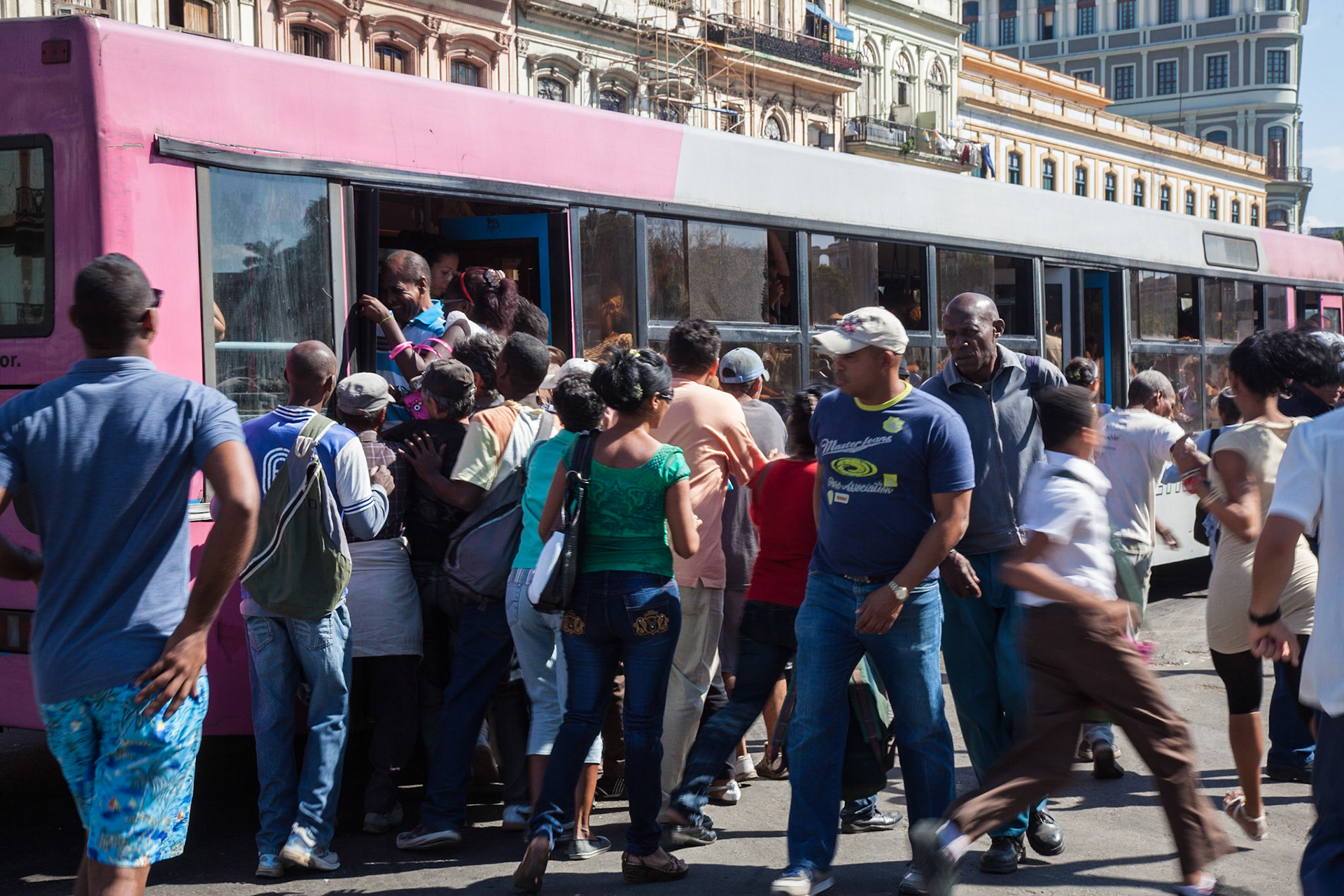 Scrambling aboard the trams in Havana