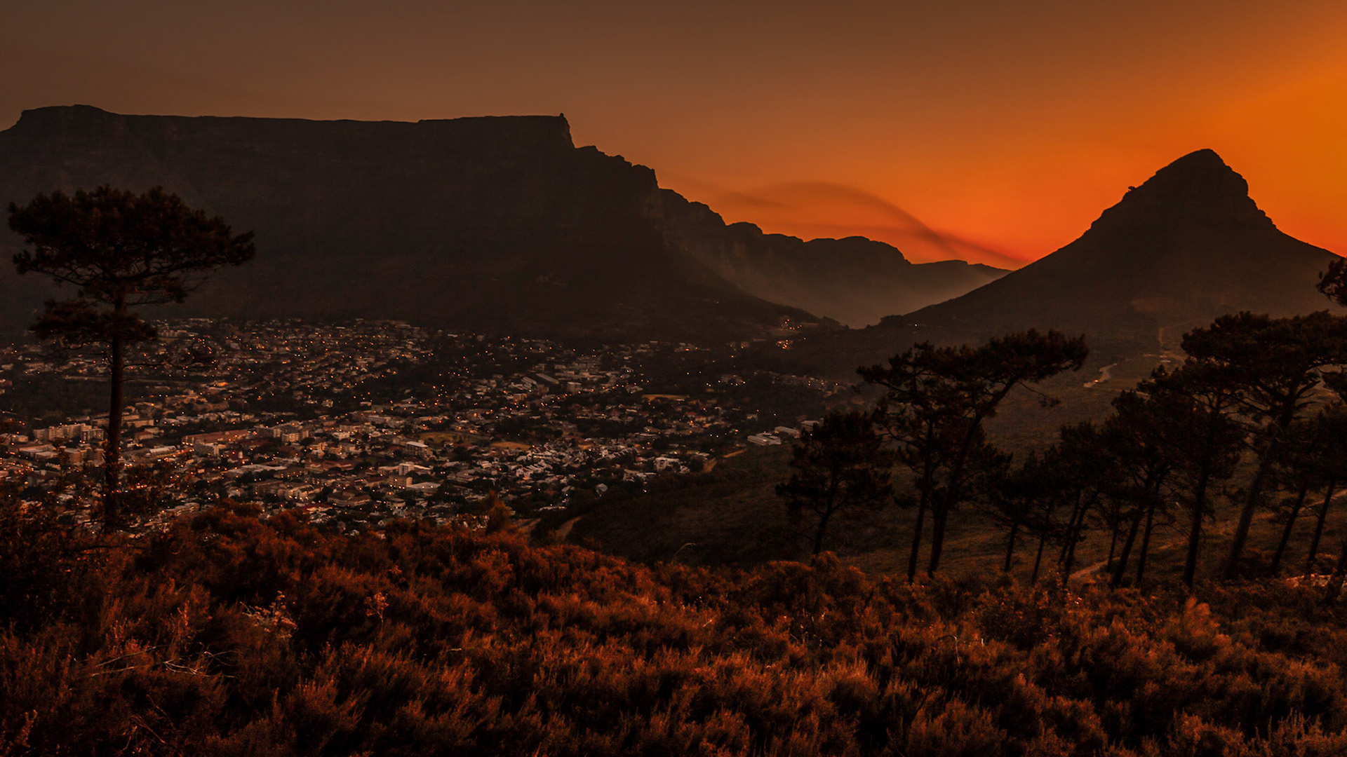 Lion's Head is a mountain in Cape Town, South Africa, between Table Mountain and Signal Hill. Lion's Head peaks at 669 metres (2,195 ft) above sea level. The peak forms part of a dramatic backdrop to the city of Cape Town and is part of the Table Mountain National Park.  Table Mountain itself, to the left, is so named because of its' unusual level plateau,  approximately 3 kilometres (2 mi) from side to side, edged by impressive cliffs.