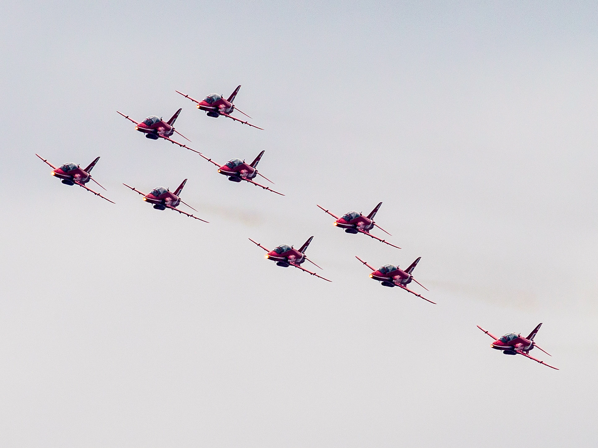 The Red Arrows, officially known as the Royal Air Force Aerobatic Team, is the aerobatics display team of the Royal Air Force based at RAF Scampton. The team was formed in late 1964 as an all-RAF team, replacing a number of unofficial teams that had been sponsored by RAF commands.The Red Arrows badge shows the aircraft in their trademark diamond nine formation, with the motto Éclat, a French word meaning "brilliance" or "excellence".