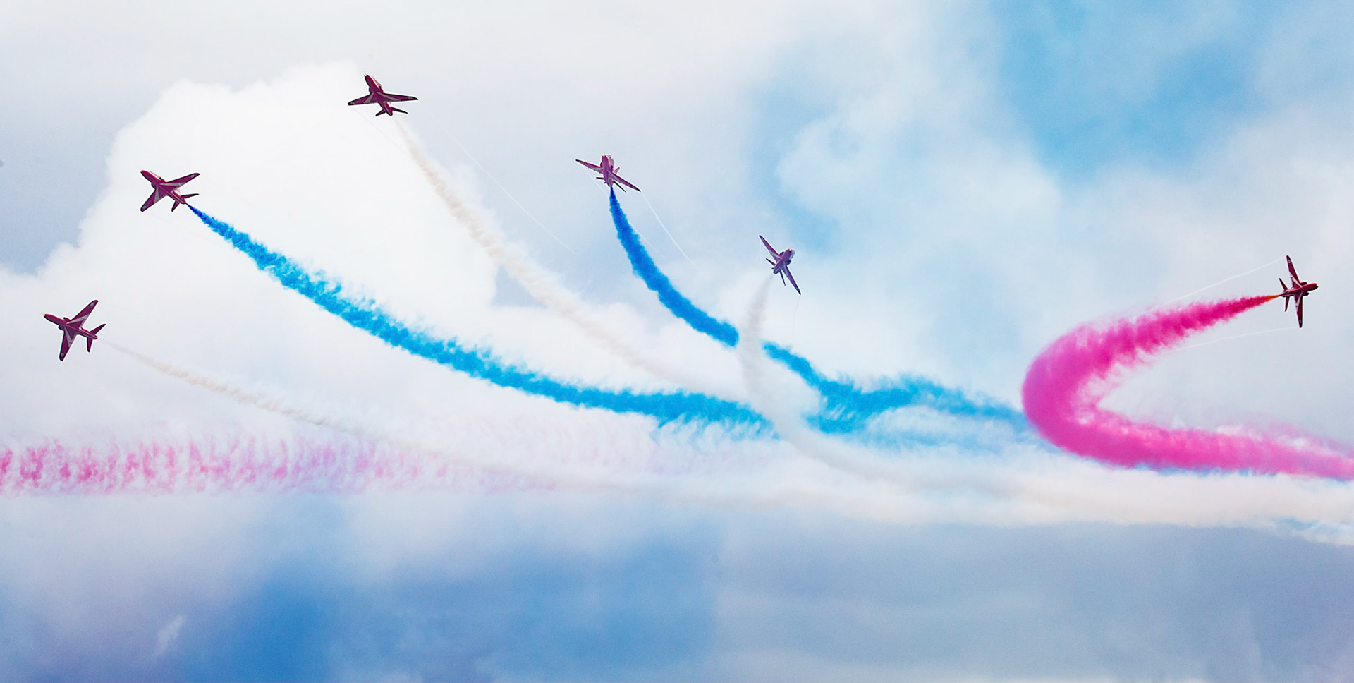 The Red Arrows, officially known as the Royal Air Force Aerobatic Team, is the aerobatics display team of the Royal Air Force based at RAF Scampton. The team was formed in late 1964 as an all-RAF team, replacing a number of unofficial teams that had been sponsored by RAF commands.The Red Arrows badge shows the aircraft in their trademark diamond nine formation, with the motto Éclat, a French word meaning "brilliance" or "excellence".