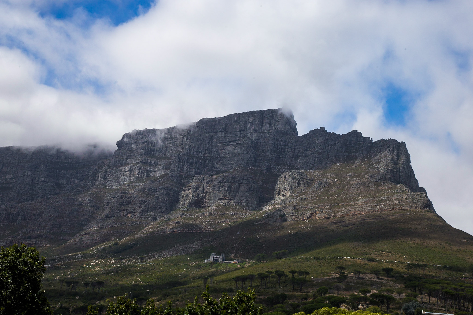 Table Mountain (Khoikhoi: Hoerikwaggo, Afrikaans: Tafelberg) is a flat-topped mountain forming a prominent landmark overlooking the city of Cape Town in South Africa, and is featured in the Flag of Cape Town and other local government insignia.[2] It is a significant tourist attraction, with many visitors using the cableway or hiking to the top. The mountain forms part of the Table Mountain National Park.