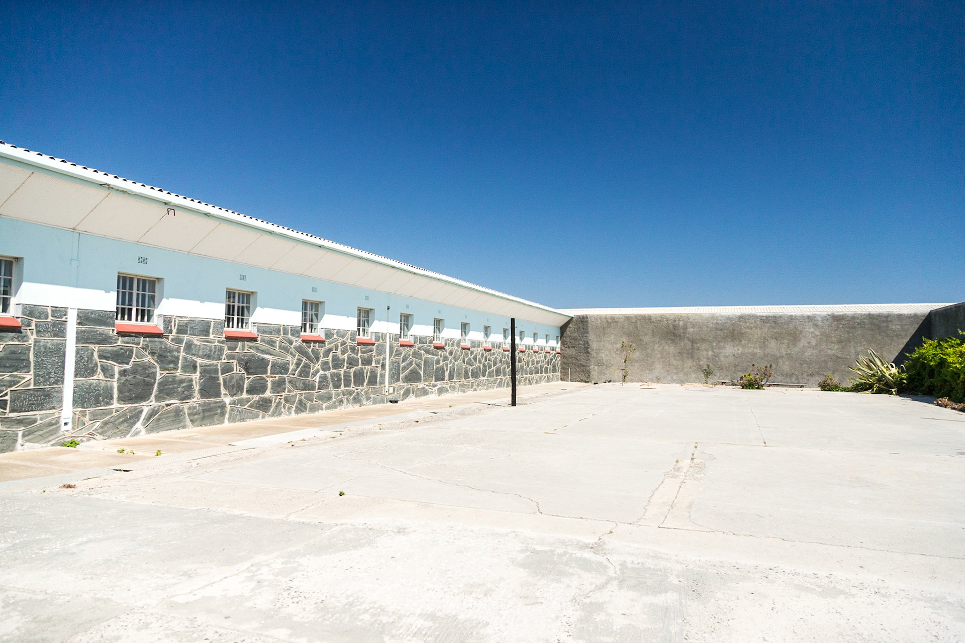 Robben Island is an island in Table Bay, 6.9 km west of Cape Town, South Africa. Robben Island is roughly oval in shape, 3.3 km long north-south, and 1.9 km wide, with an area of 5.07 km². It is flat and only a few metres above sea level. Nobel Laureate and former President of South Africa Nelson Mandela was imprisoned there for 18 of the 27 years he served behind bars before the fall of apartheid. Robben Island is both a South African National Heritage Site as well as a UNESCO World Heritage Site. The Island was used as a prison for political prisoners and convicted criminals from 1961. It was a maximum security prison for political prisoners until 1991. The medium security prison for criminal prisoners was closed in 1996.