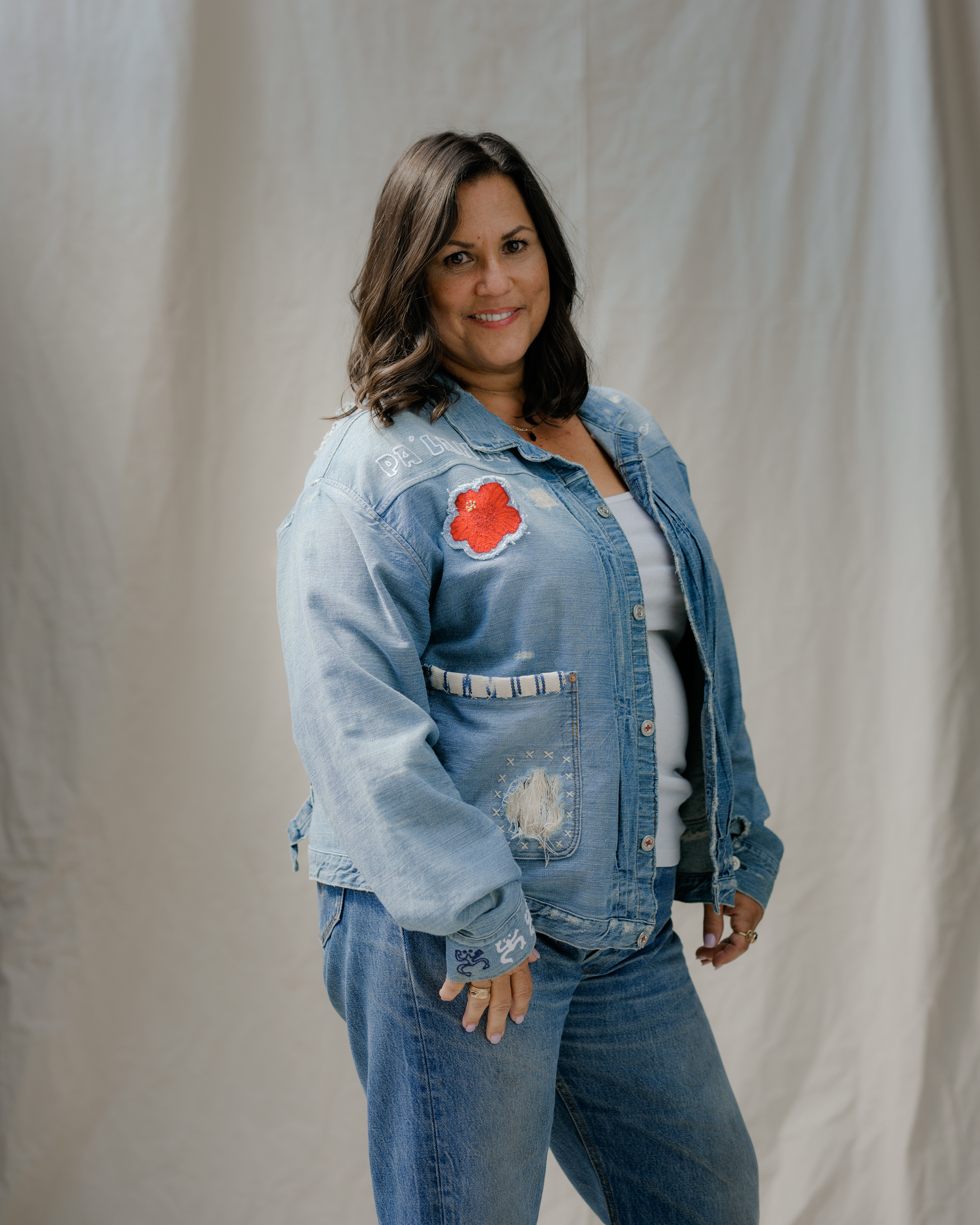 An embroidered red hibiscus compliments phrase Pa'Lante in Puerto Rican culture