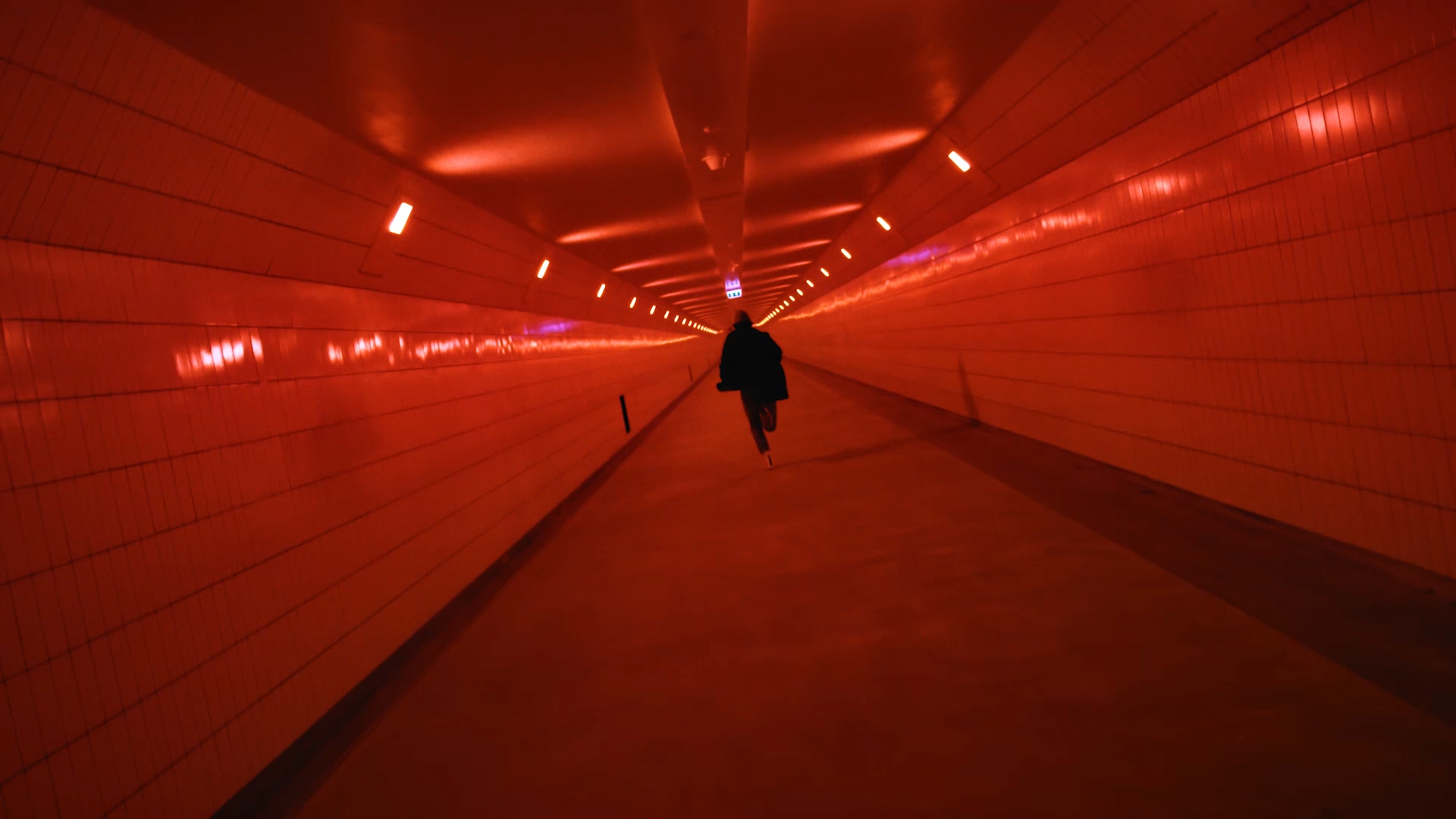 een screen grab uit de video voor de geemente rotterdam, Tom rent hier door de maastunnel die noord en zuid met elkaar verbind. wat een model is het toch ook. Vastgelegd door Olaf Tijhuis. DOP en Video Editor uit Rotterdam.