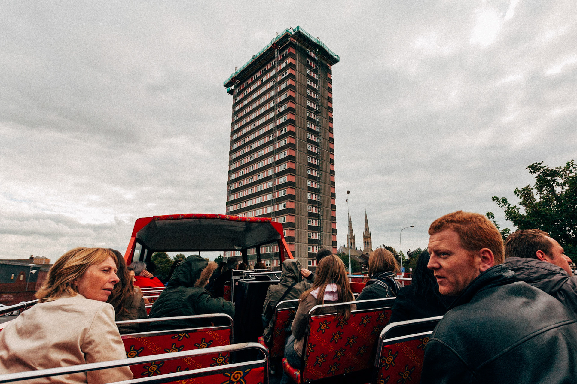 The Belfast City Tour. L'autobus turistico scoperto attraversa la città, mostrando ai turisti i luoghi chiave della città, tra cui palazzi e alberghi oggetto continuo di attentati nelgi anni settant a e ottanta.