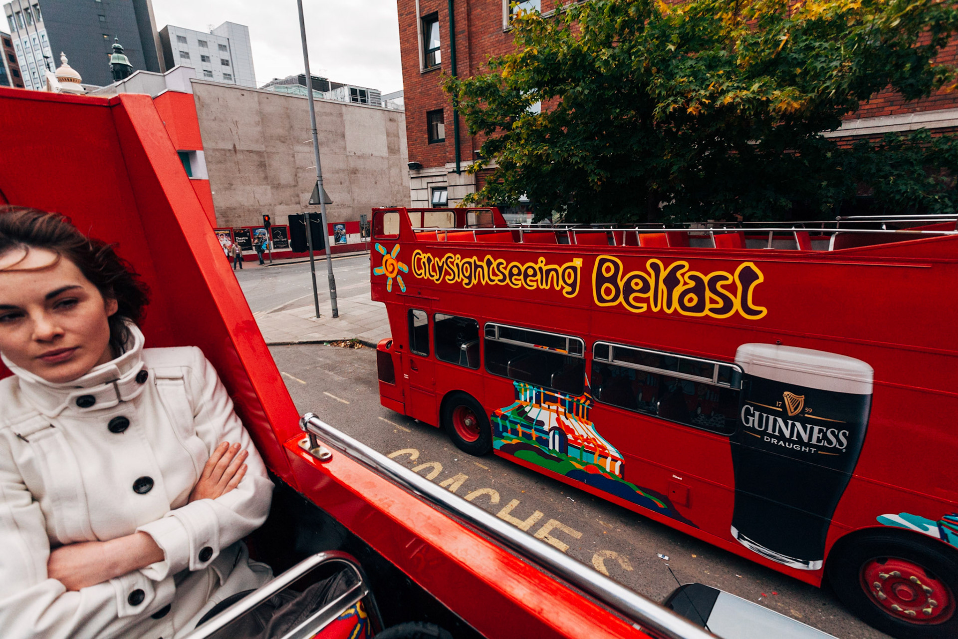 The Belfast City Tour. L'autobus turistico scoperto attraversa la città, mostrando ai turisti i luoghi chiave della città, tra cui palazzi e alberghi oggetto continuo di attentati nelgi anni settant a e ottanta.