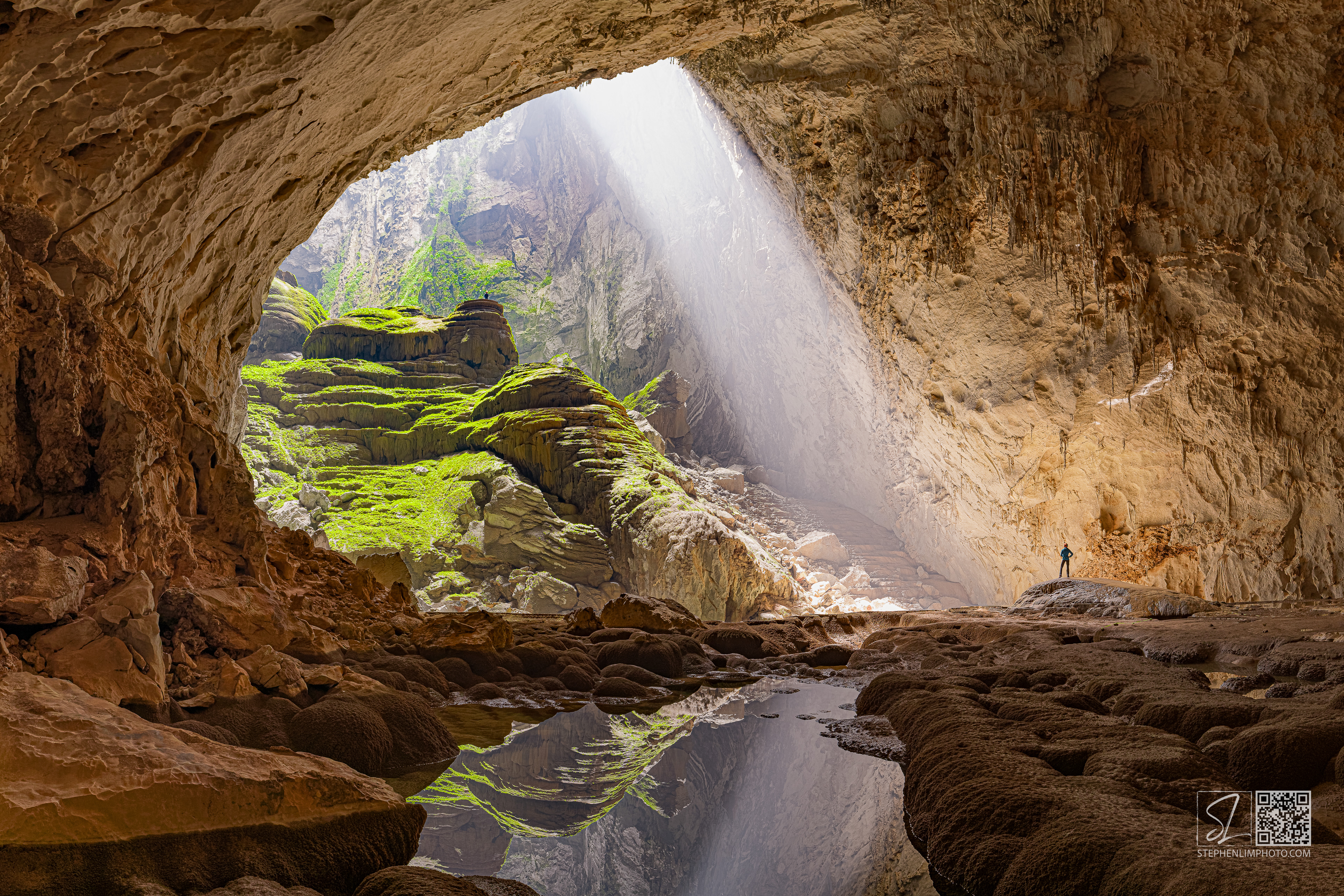 Waiting for Enlightenment:  Cavers exploring Son Doong  with a sunbeam and reflection