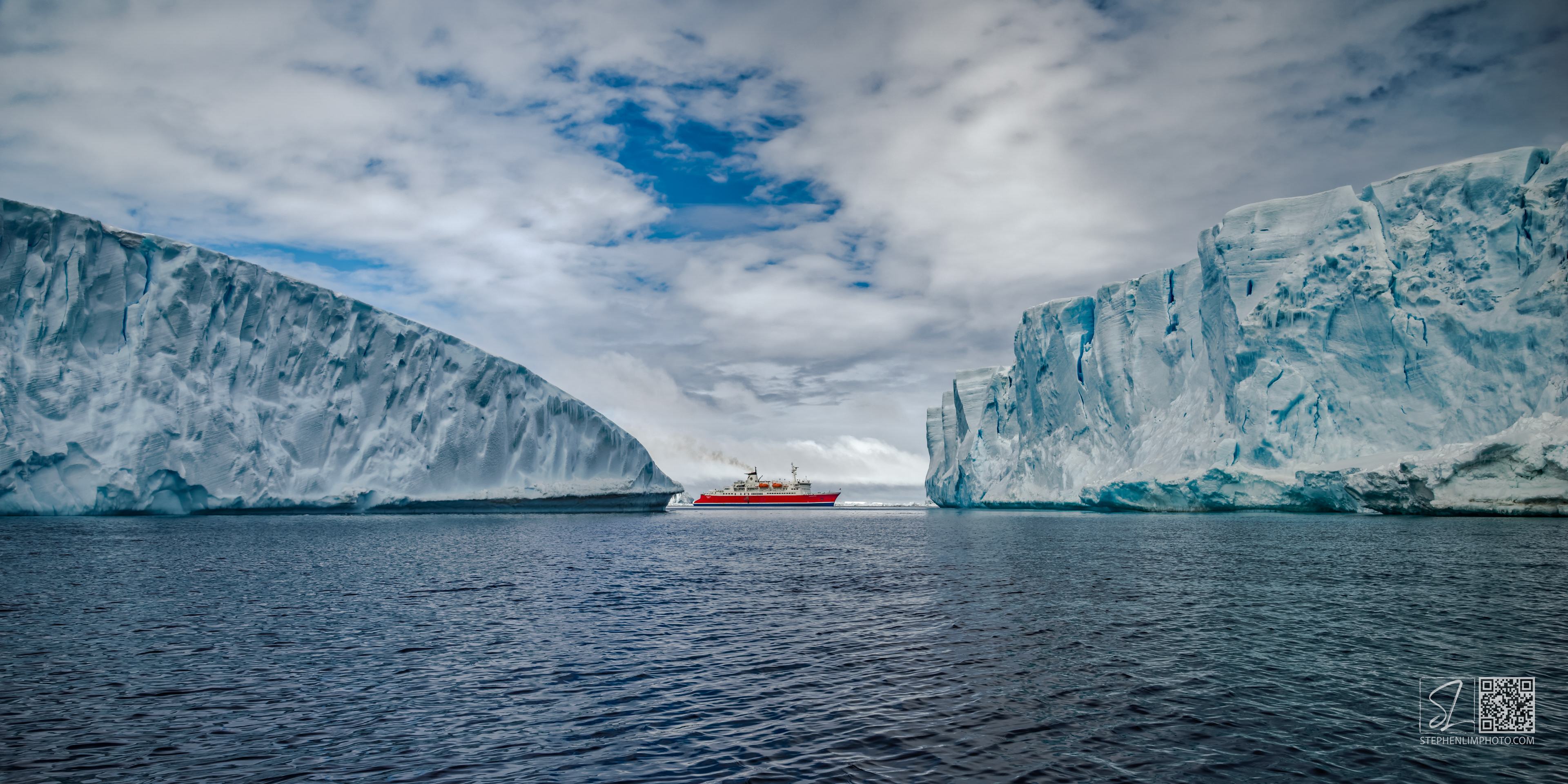 Wedged in the Weddell:  A ship is dwarfed by two massive icebergs in the sea.