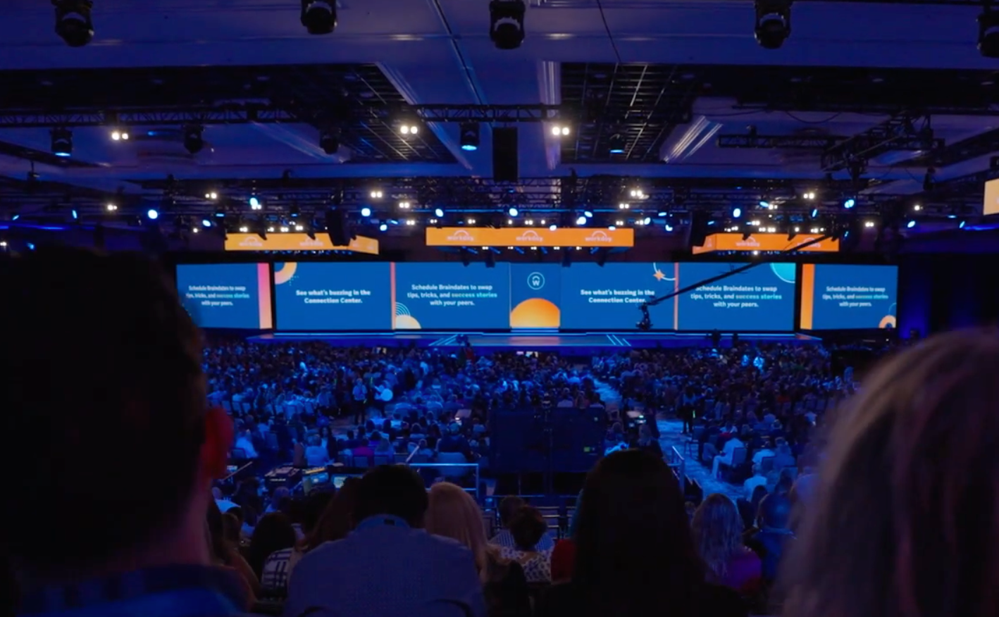 Conference image with screens and seated people