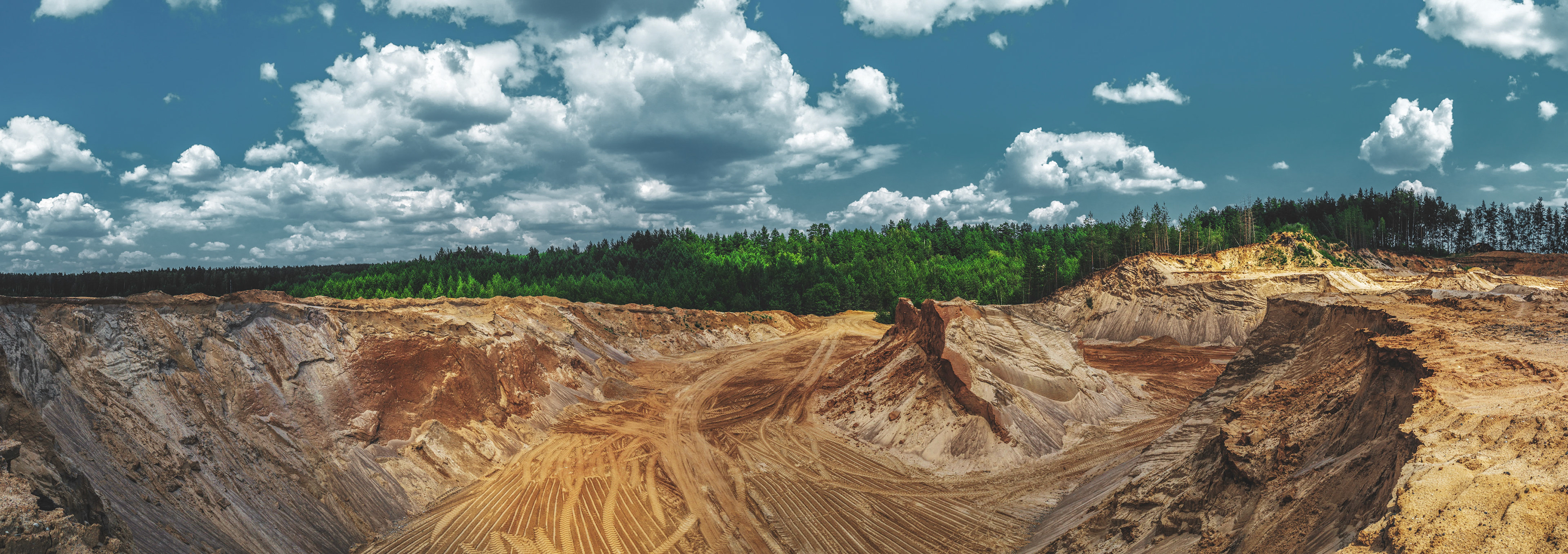 Color toned panorama of sand quarry and forest