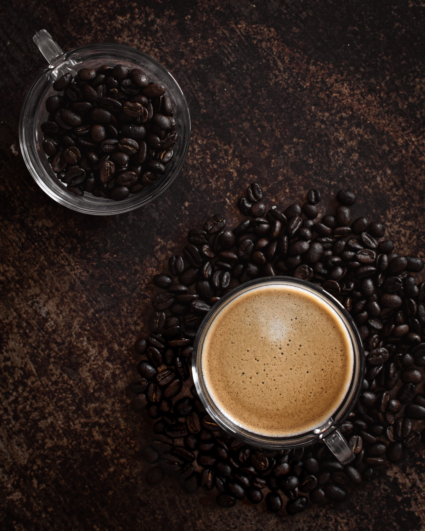 coffee in the middle of coffee beans, a cup of coffee beans and brown backdrop
