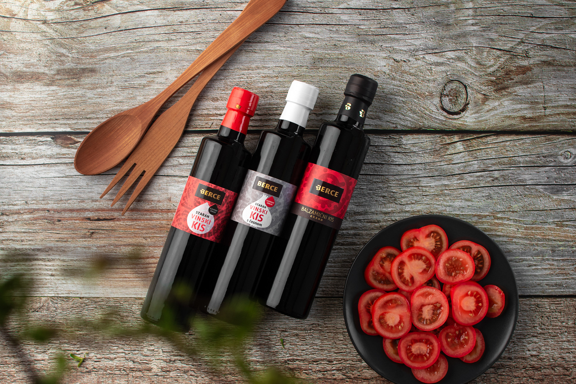 bottles of vinegar, tomato salad on wooden table