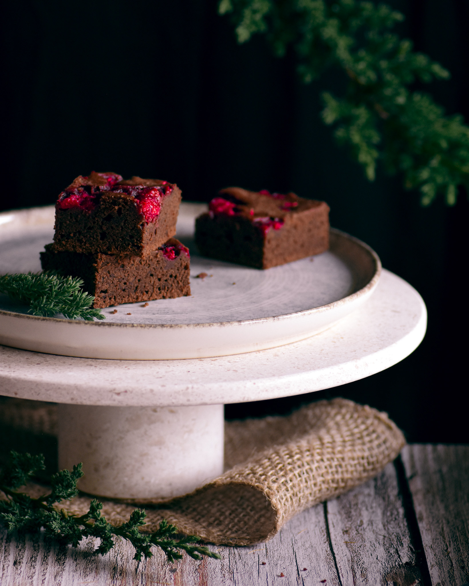 Raspberry brownies in christmas mood on a white cake stand
