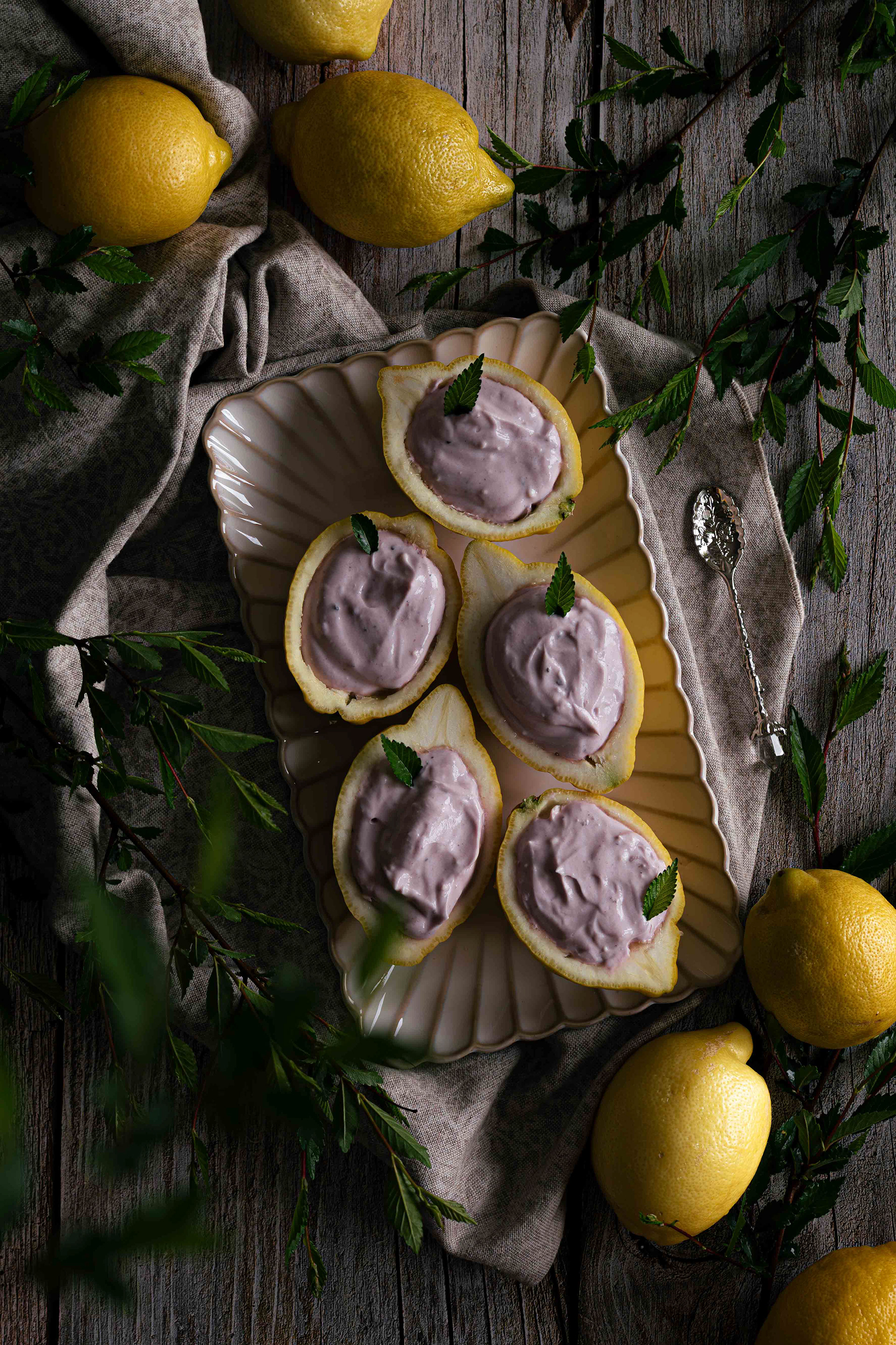 lemon posset with blueberries and greenery on a wooden backdrop