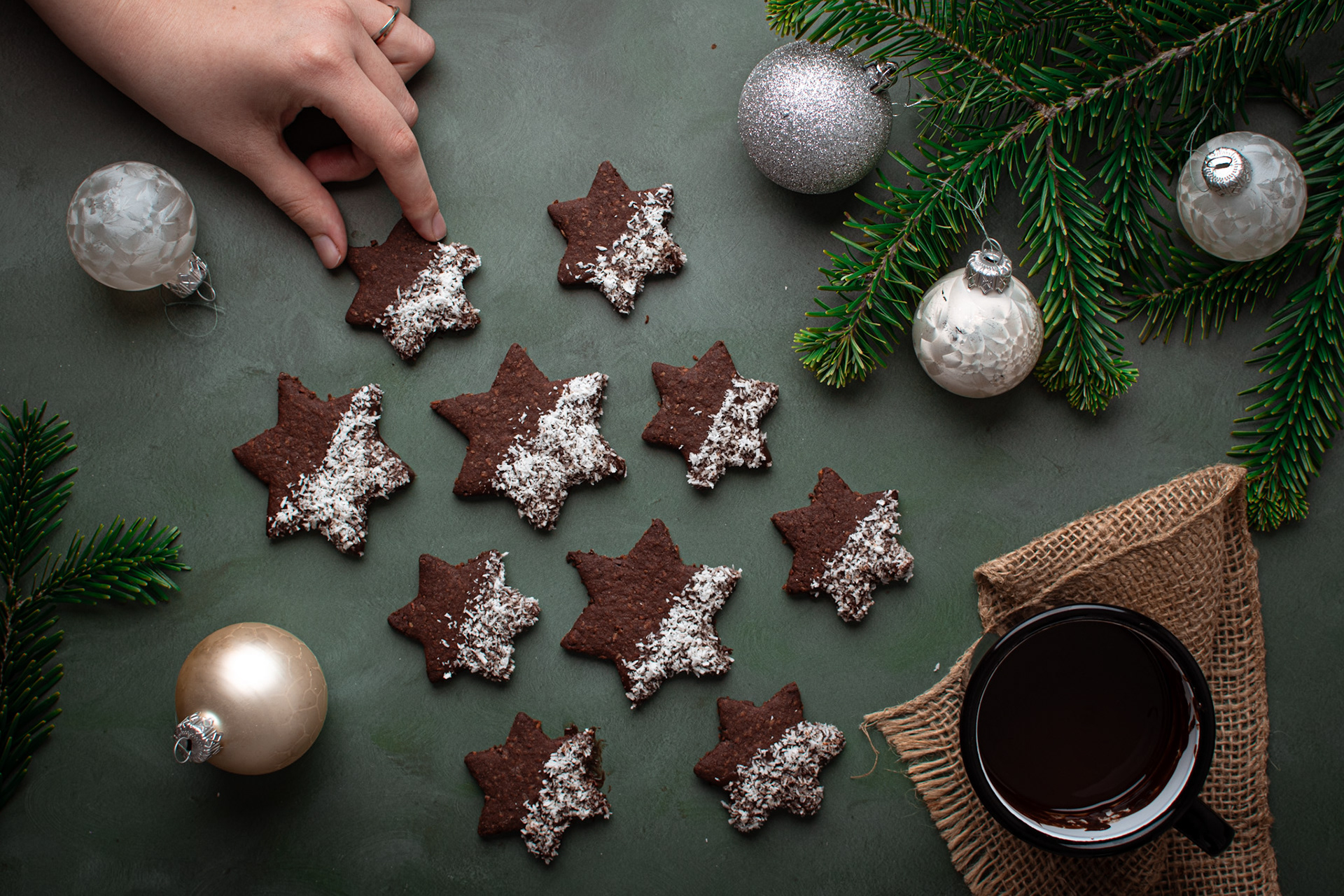 Christmas chocolate cookies in star shapes, christmas tree branch, cup of hot chocolate