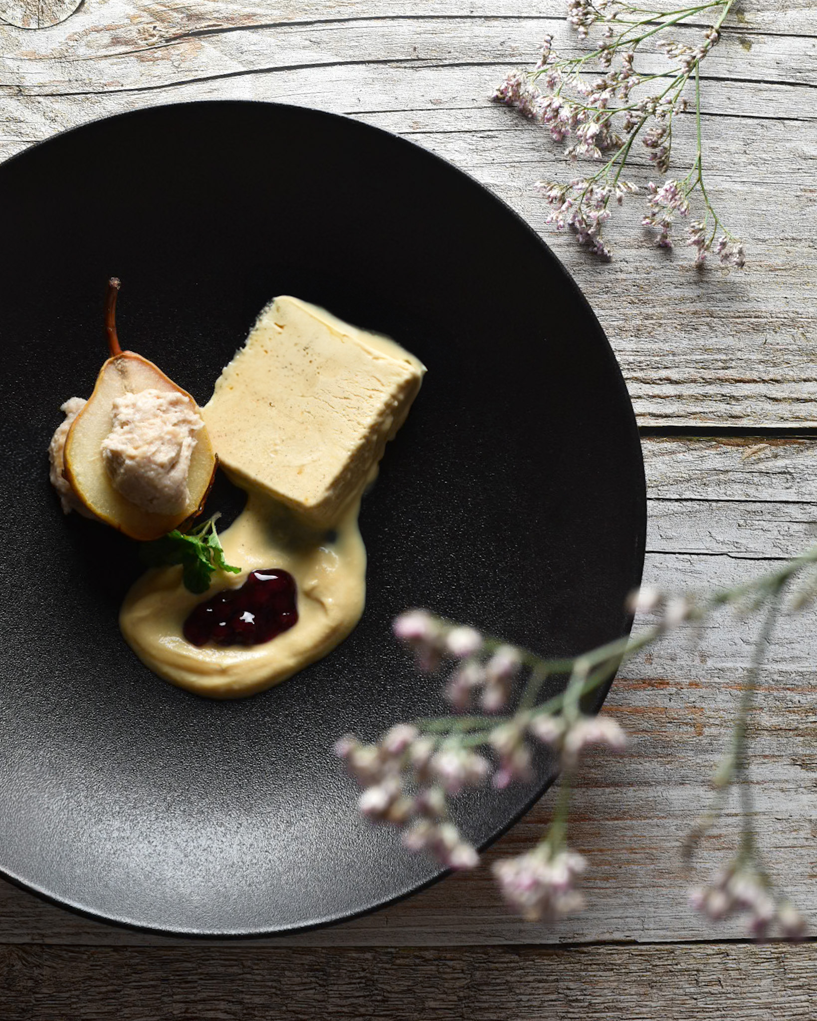 sladica s hruško in sladoledom na leseni podlagi z rožami