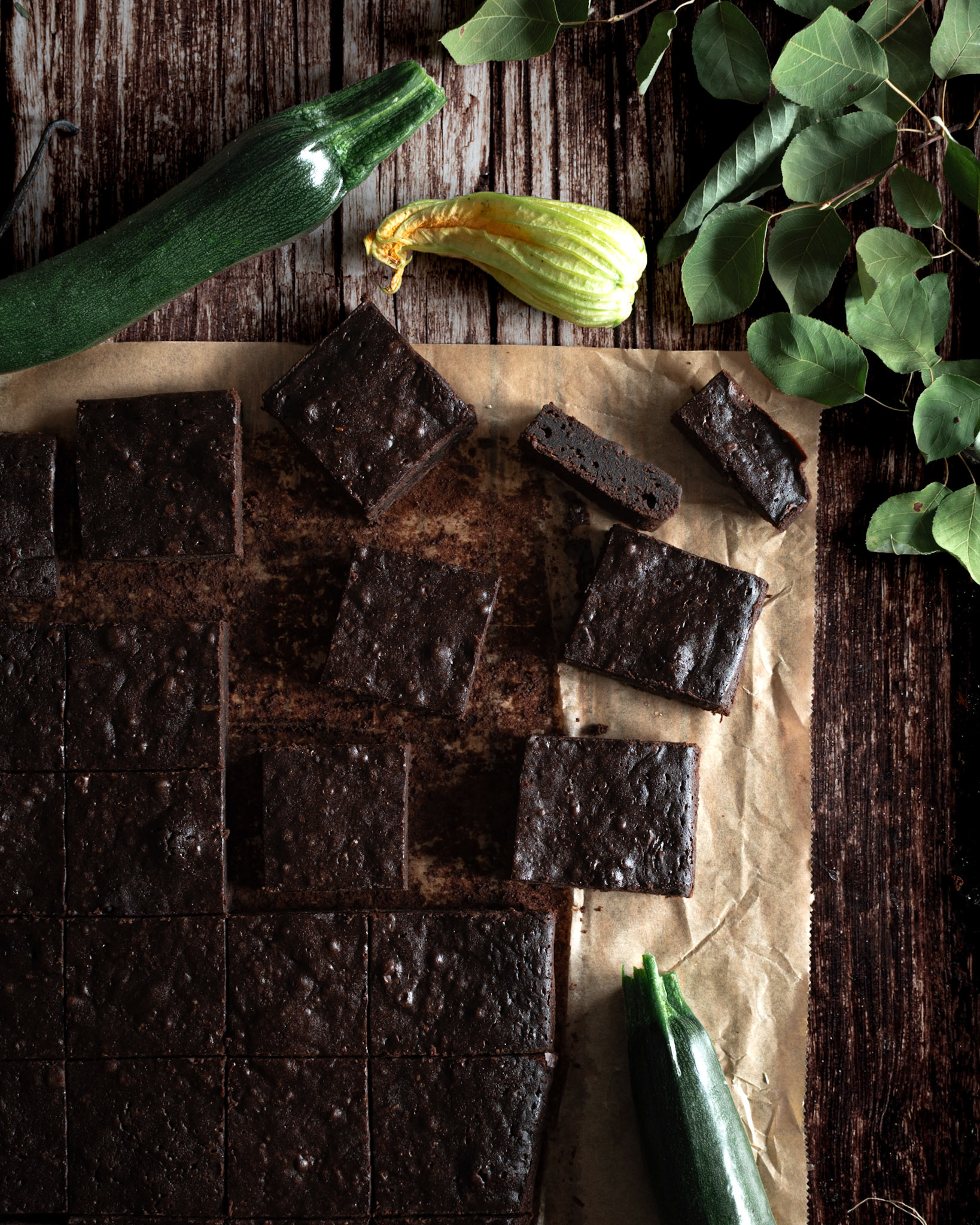 zucchini brownies with leaves on a dark wooden table