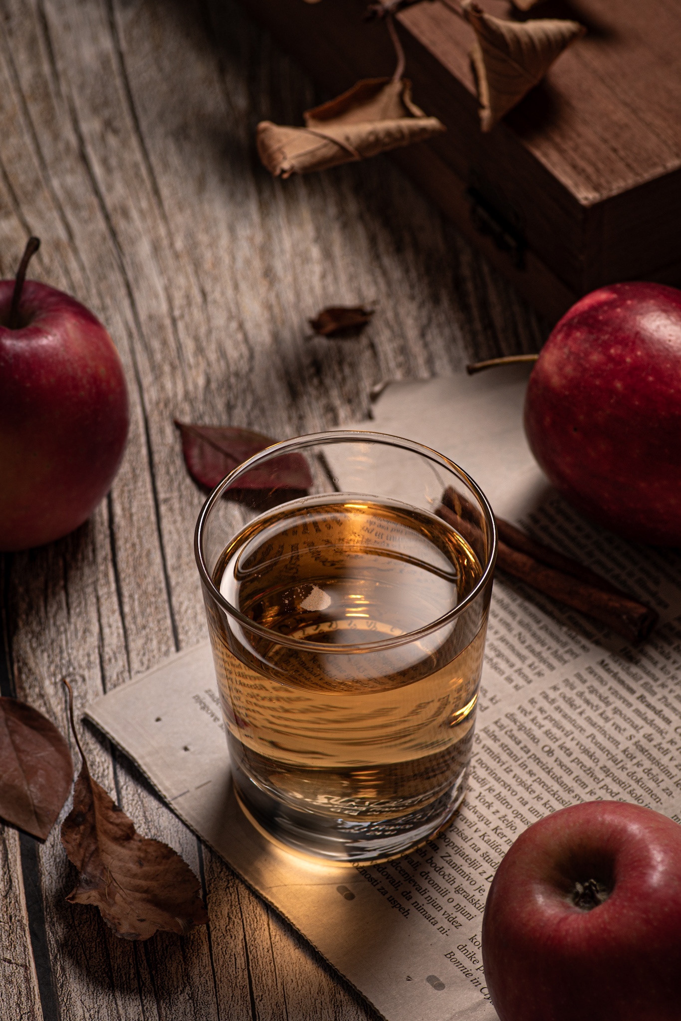 apple cider on newspaper with apples