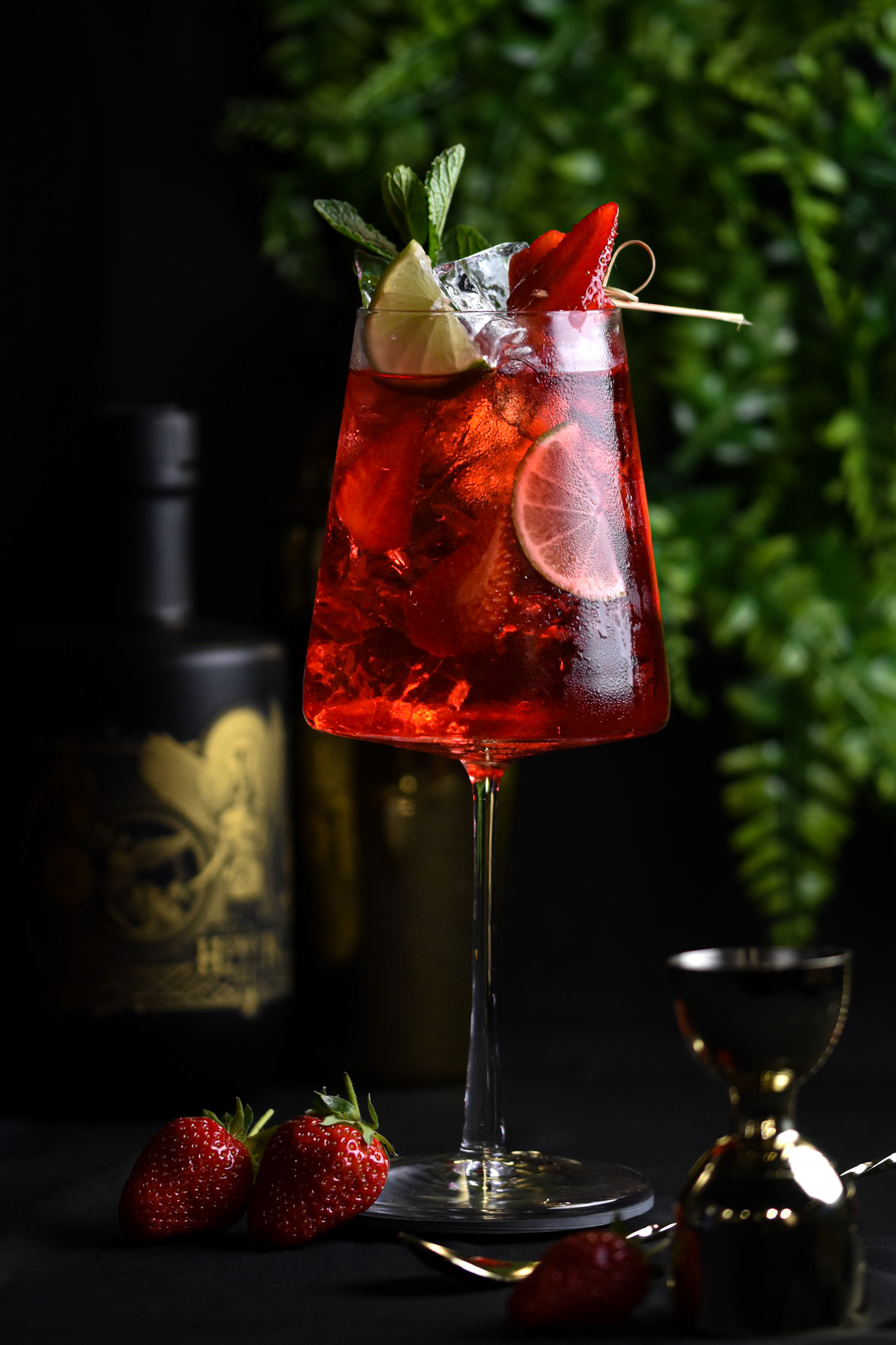 red cocktail with greenery and strawberries
