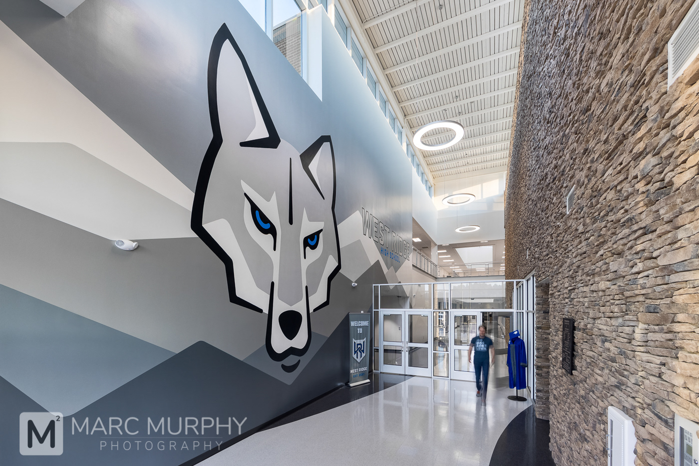 West Ridge High School Entrance Entry Foyer with lights, stone wall and large wolf mural