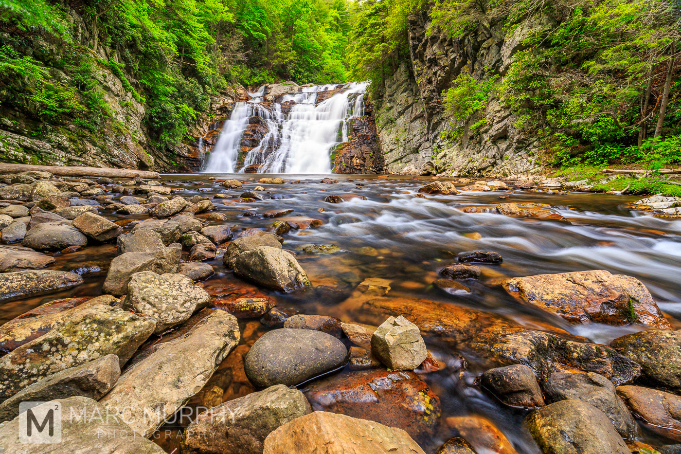 Laurel Fork Falls East Tennessee Waterfall in Spring with River and Rocks in Foreground Surrounded by Green Trees