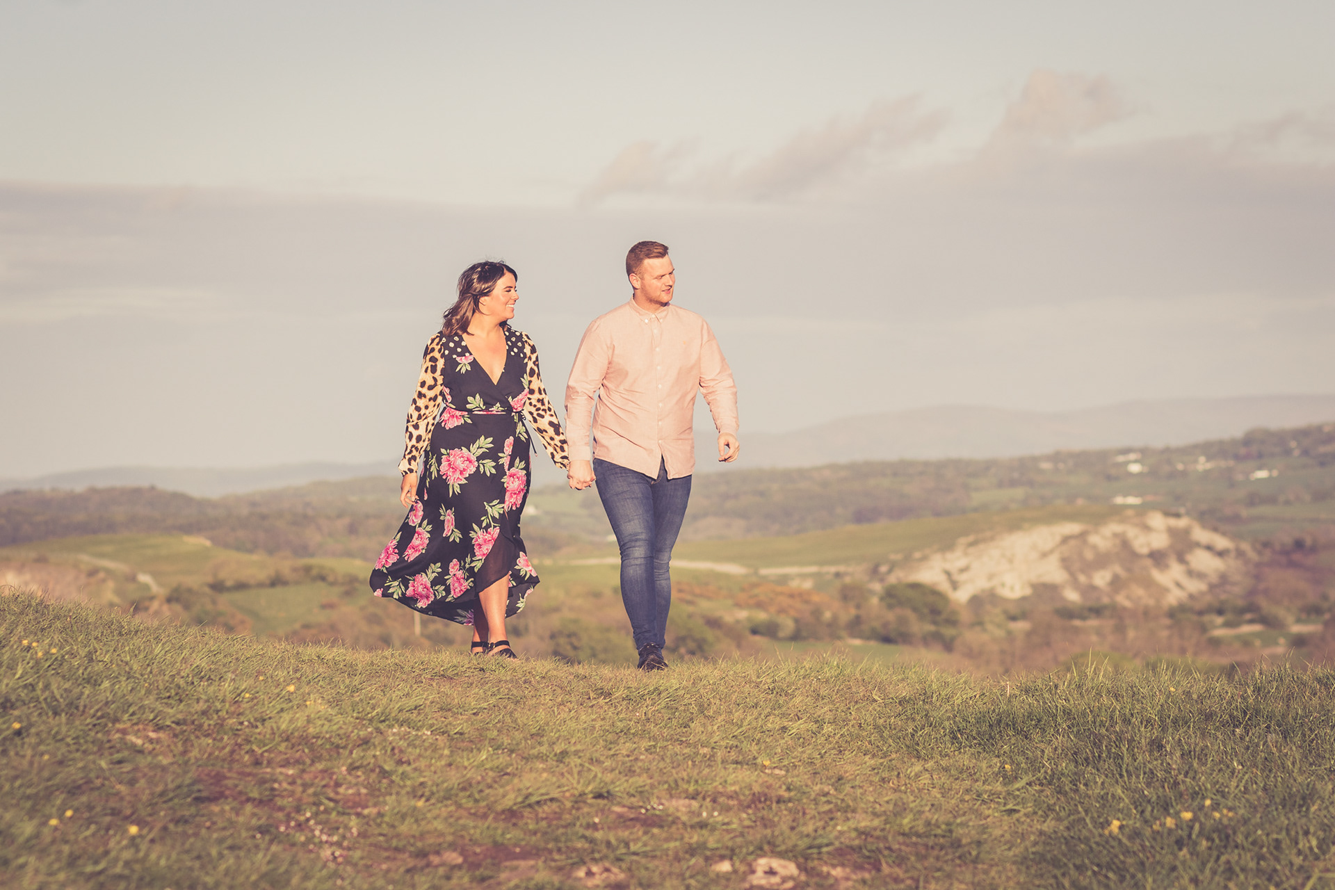 Couple Engagement portrait. The couple are walking holding hands walking through the North Wales countryside. Taken during an Engagement photo shoot.